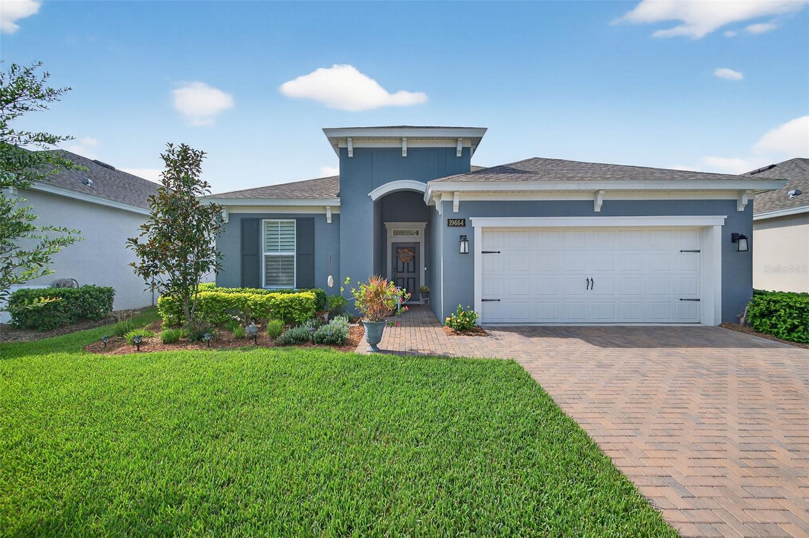 Driving through the gated entrance of Cascades at Southern Hills, you’re immediately greeted by oak-lined streets and a sense of tranquility. This 55+ community is tucked within Florida’s natural beauty, offering peace and privacy while still connecting you to an active lifestyle. One of the unique advantages here is the optional social membership to the Southern Hills Plantation Club that is available.
As you arrive at the home, the brick-paved driveway and manicured landscaping set a welcoming tone.
Inside, soaring ceilings and tall doors immediately create a sense of spaciousness. The open-concept design blends the kitchen, dining, and great room into a bright, inviting space. The kitchen is both stylish and practical, with stainless steel appliances, quartz countertops, a gas stove, and a generous island for meals, prep, or conversation. Plantation shutters frame the windows, adding a timeless touch to every room.
The owner’s suite is a retreat designed for comfort, complete with a walk-in closet and a beautiful, large walk-in shower in the ensuite bath. A flexible bonus room just off the suite is ideal for a home office, den, or hobby space. Guests will enjoy their own comfortable bedroom and nearby full bath, offering privacy for everyone.
Perhaps one of the most appealing features is the enclosed and screened patio, already completed for you, overlooking the landscaped backyard with added palms and plantings. It’s the perfect spot to enjoy your morning coffee or an evening breeze without the extra expense and wait that comes with a new build.
Additional upgrades include a power shade, ceiling fans in every room (and on the porch), custom lighting, self-closing cabinets, and a water softener system. A 5-ton Trane AC provides efficient comfort, and the 10-year transferable structural warranty offers peace of mind for years to come. The washer and dryer are also included, making move-in effortless.
Living here means more than just the home itself. The HOA covers cable, lawn mowing, fertilizing, pest treatments, and irrigation, giving you time to enjoy the community amenities. Take a swim in the lap pool, join a pickleball match, or relax by the fire pits with friends. The clubhouse offers both fitness and leisure, creating a lifestyle as active or relaxed as you choose.
This home combines the charm of an established residence with the benefits of newer construction, plus the advantage of thoughtful upgrades already in place. Come experience it for yourself and see why Cascades at Southern Hills is more than just a neighborhood; it’s a way of life.