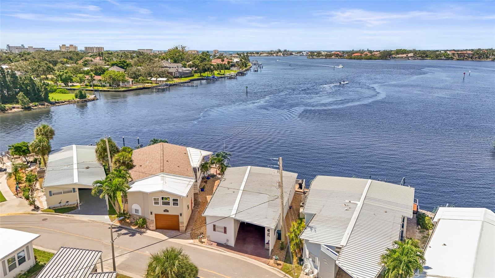 Enjoy stunning panoramic views of Roberts Bay from three hurricane-rated sliding doors. Watch dolphins, manatees, and seabirds from your own backyard! Opportunity to add a boat lift or dock in this sailboat water access and take a 5-minute ride to the Gulf of Mexico — no bridges!
This home features a large deck for dining, entertaining, and relaxing while overlooking the bay. Electric retractable Sunbrella awnings provide shade, and the sunsets are nothing short of spectacular.
Inside you’ll find 1,400 sq. ft. of open living space, 2 bedrooms, 2 full baths, and brand-new porcelain tile. The kitchen boasts granite countertops, newer appliances, and a great flow into the dining and living room. The guest room doubles as an office with a Murphy bed. The home also includes a full-size laundry room, mirrored walls to reflect water views, and a built-in wet bar.
Additional upgrades include newer A/C, track lighting, and a large covered carport with paver driveway, tool/work room, and storage.
Located in a vibrant 55+ waterfront community with low HOA fees, resort-style pool, tennis, clubhouse, and daily activities. Move-in ready, meticulously maintained, and perfect for entertaining — watch fireworks from your deck. Enjoy and easy walk across the Venice Bridge and stroll through Downtown Venice Ave. Pets are welcome!