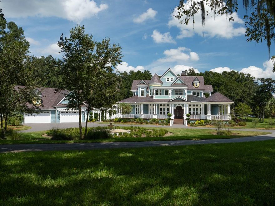 Nestled on 41.70 acres in Summerfield, just a short distance from the Florida Horse Park, this unique property offers a rare combination of natural beauty and equestrian functionality. This property features incredible elevated views overlooking a serene 4-acre lake, surrounded by mature oak trees and fruit trees, creating a tranquil setting. The Victorian-style two-story home, with its classic wrap-around porch and balconies, offers 4 bedrooms, each one with meticulous detail, 5 bathrooms, and an office. A standout feature is the unique wine cellar, complete with a climate-controlled wine room and custom wine racks. The stone-clad walls and staircase in the cellar add a distinctive touch to this elegant space. The two-story, air-conditioned 4-car garage includes a full bathroom, providing ample space for vehicles and equipment, while offering the convenience of additional living or workspace. The property also includes a large 48x38 workshop with air conditioning, a fireplace, a full bathroom, and a loft, ideal for a variety of projects or storage. An open-air pole barn with a concrete floor and sliding barn doors houses a storage/tack room, with stairs leading to a loft area above for extra storage. Offering stunning views this estate seamlessly blends practicality with the natural beauty of its surroundings.