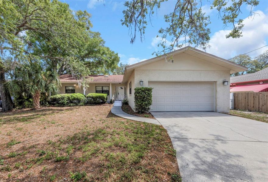 Location.  This home features 3 bedrooms 2 bathrooms with an oversized 2 car garage. This home features a large open floor plan with split bedrooms. When walking into the home you will notice the nice high ceilings with 2 skylights. Kitchen is super functional with plenty of kitchen cabinets along with a pantry. Kitchen has granite countertops as well as an L shaped breakfast bar that comes with 4 bar stools. Dining room table stays with the home as it matches the breakfast bar, this table also comes with 4 chairs. Living room has a beautiful wood burning fireplace. Please note the living room also features French doors that lead out to a screened in porch with a lovely jacuzzi. Backyard is large enough for a pool and is fully fenced. Master bedroom features 2 walk-in closets, 1 could possibly be converted to a nursery. Master bathroom is large with dual sinks, a large shower as well as an additional linen closet. 2nd and 3rd bedroom feature large closets as well as ceiling fans. Actually every room has a ceiling fan. This home has a beautiful front porch and it handicap accessible. It is also located 5 to downtown Tarpon Springs, sponge docks, buses and shopping. Multiple churches are between 5-10 minutes. TPA is approximately 30 minutes.  This home is very private and secluded yet close enough to anything that may peak your interest. This home is located in a flood zone however there has never been any water past the mailbox.  Please pass along (in regards to flood insurance) "This home has an Annual Increase Cap Discount that Stays with the Home" making flood insurance super affordable. Do not hesitate to call me with any questions you may have.