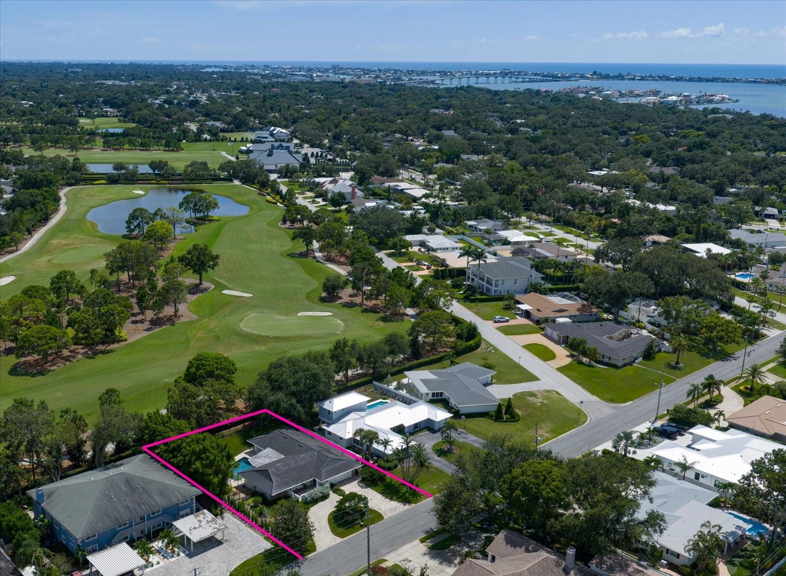 Nestled in the heart of Belleair and perfectly positioned to overlook the prestigious Pelican Golf Course, this stunning residence combines elegant design, luxurious finishes, and an unbeatable location. A circular pavered driveway sets the stage with impressive curb appeal, welcoming you into a thoughtfully crafted, open, and flexible floor plan. Travertine flooring flows throughout most of the home, beginning with a gracious foyer that opens into a spacious dining and living room combination ideal for both casual gatherings and formal entertaining. At the center of the home, the custom kitchen is a true showpiece, featuring a generous island with seating, granite countertops, tumbled stone backsplash, stainless-steel appliances, undercabinet lighting, an appliance garage, dry bar, and pantry. Pocket sliders in both the living and family rooms open to the outdoors, effortlessly connecting indoor and outdoor living for easy entertaining and unforgettable moments. The family room offers custom built-ins that complement the kitchen, while the spacious laundry room, complete with plentiful counter space and storage, and a built-in desk, adds flexibility for use as a home office. A desirable split bedroom plan ensures privacy, with a luxurious primary suite offering French doors to the pool, a custom walk-in closet, and a spa-like ensuite with a walk-in shower and granite vanity. Two additional bedrooms share a Jack and Jill bath, while the fourth bedroom overlooks the pool and shares a striking, glass-tiled wet bath that also serves as a pool bath. Additional highlights include plantation shutters, custom closet systems in all bedrooms, recessed lighting, a reverse osmosis system, water softener, under-eave exterior lighting, and smart features such as a front door lock, doorbell, sprinkler system, backyard cameras, and lighting. Just across the street from the Belleair Rec Center, offering tennis, pickleball, a playground, summer camps, and so much more, this home presents a rare opportunity to live in one of Pinellas County’s most desirable communities—close to boutique shopping, acclaimed restaurants, sparkling beaches, and two international airports.