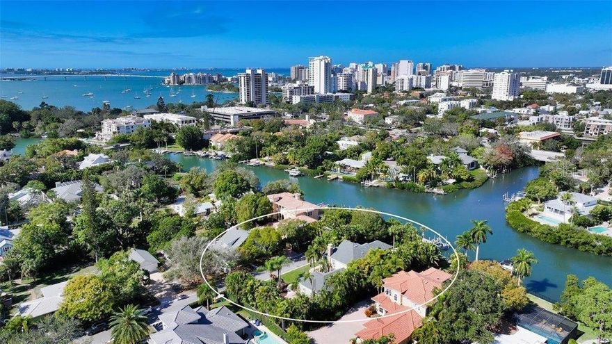 WEST OF THE TRAIL WATERFRONT… Welcome to this classic home with a coastal flair, located just minutes from downtown Sarasota. A fabulous location, a smart floor plan, dock with lift and water views of Hudson Bayou; create a winning combination. Over 4,200 SF of beautiful living space, this custom home features enhanced architectural details, 12’ ceilings, custom trim work, thick crown moldings, tray & coffered ceilings with beams & beadboard detailing, maple hardwood floors adding charm & character. Ample room for entertainment with formal living & dining areas, plus a spacious open family room with gas fireplace. Large sliding doors leading to the two covered porches; one for lounging, the other with grill & dining area. The large, heated saltwater pool and spa are surrounded by a travertine deck & lush foliage. For boating enthusiasts, the dock has a 16,000 lift, & just one bridge to the bay, just minutes to Marina Jack’s. Stylish Chef’s kitchen is appointed w/ custom cabinetry, quartzite counters, & Kitchen Aid stainless steel appliances. A large  center island, breakfast bar & casual dining area overlooking the pool, provide the perfect spot for informal meals. The first-floor primary retreat features; large sliders to the lanai, double walk-in closets & spa-inspired bath. The first-floor den/office (with Murphy bed) could be a 5th bedroom w/access to a full bathroom & hall closets. Another hall closet is prepared for an elevator should you need one. The 2nd level offers a large loft/family room, three additional generous sized bedrooms, & two full baths. A large 3-car garage & huge driveway make way for great parking. Enjoy launching your boat from the 20X4 dock with 16,000lb lift, or just fish from your dock!! ***PLEASE NOTE: This home is in the X flood zone, some of land is AE. No damage or flooding with the recent storms. Roof replaced in December 2023, AC systems & HW heater 2020. Located just a short stroll to downtown Sarasota, theaters, dining, Southside Village. Meet your neighbors at Pomelo Park just around the corner. An amazing home in a fabulous location West of the Trail!!