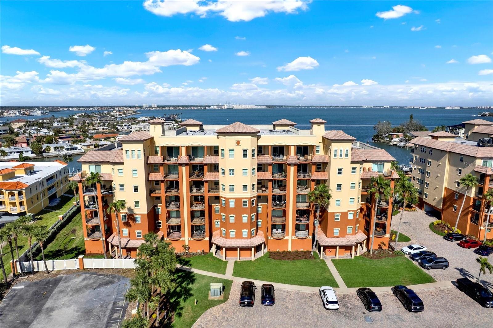 Welcome to your private coastal retreat—a stunning 3-bedroom, 3-bathroom luxury condo offering over 2,400 square feet of refined living in the heart of St. Pete Beach. Perfectly positioned between the Gulf of America and the serene Intracoastal Waterway, this residence blends timeless sophistication with the ultimate Florida lifestyle. Step inside through your private foyer—easily accessed by elevator—and be captivated by sweeping water views and impeccable finishes throughout. The spacious open-concept living area flows effortlessly to a large waterfront balcony, the perfect setting to enjoy breathtaking sunrises over the Intracoastal. Each of the three bedrooms offers private balcony access, creating seamless indoor-outdoor living and showcasing partial Gulf views and unforgettable sunsets. The owner's suite is a peaceful haven, overlooking the water with a spa-inspired ensuite featuring a walk-through stand-up shower, double vanity, linen closet, and an oversized walk-in closet complete with custom built-ins. The second bedroom offers an ensuite bath and generous closet space, while the third bedroom—set at the front of the unit—boasts beautiful Gulf glimpses and ideal separation for guests or an office. Adjacent to the second two bedrooms is a third full bathroom which offers ease of use for guest and makes entertaining a breeze. At the heart of the home, the chef’s kitchen features rich beveled wood cabinetry, a large island for gathering, an in-wall oven, stainless steel appliances, and a statement range hood. Adjacent, the dining area includes a stylish wet bar with a brand-new bar fridge—perfect for entertaining. Additional highlights include Key West-style shutters throughout, a spacious laundry room and walk-in pantry, ample storage, and a detached two-car garage located on a lower level. The gated community offers premium amenities including abundant guest parking, a gorgeous pool area overlooking the Intracoastal, and available boat slips on a first-come, first-serve basis for separate purchase. Live where others vacation—just minutes from world-class beaches, top-rated restaurants, boutique shopping, and quick access to the interstate. This exceptional condo is more than a home—it's a statement of luxury, comfort, and coastal living.