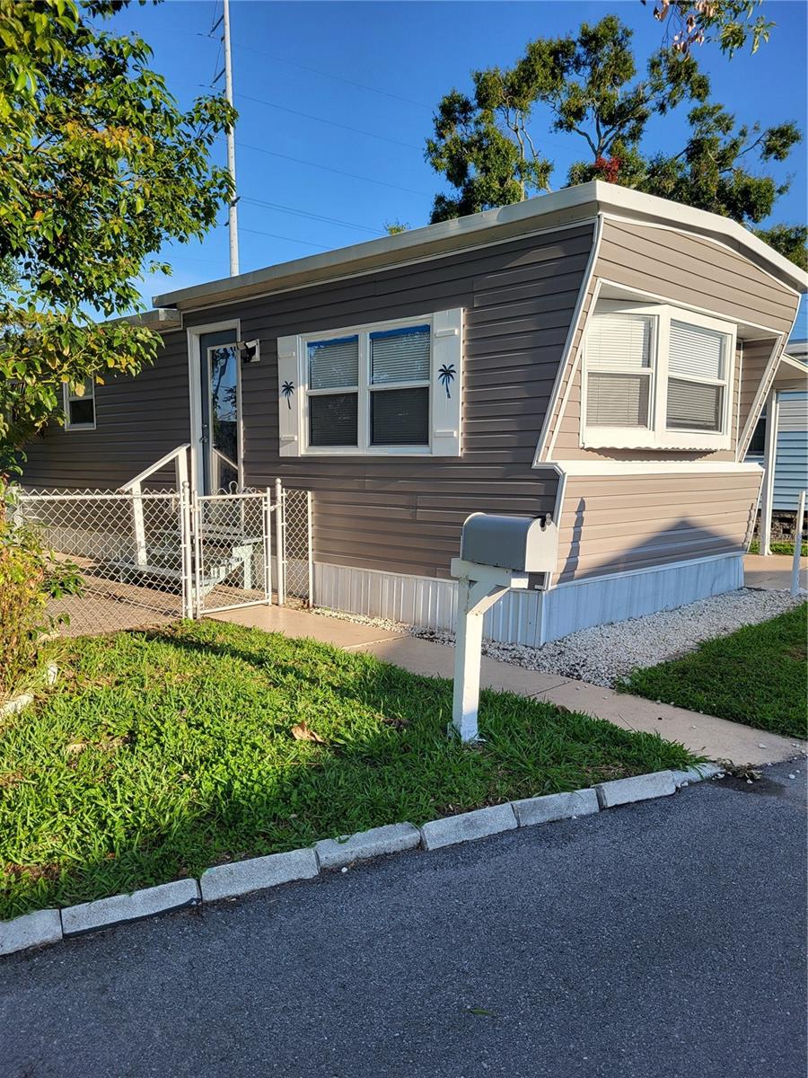Bright and light, adorable 2/1 in Holiday Village. Central a/c (2023), updated windows, newer flooring, tiled walk in shower. No lot rent, pet friendly, all age and low HOA fee of $150 mthly (includes water, sewer, lawn maintenance and onsite manager. Private fenced yard with tropical landscaping. Carport and large storage building with washer and dryer and ample storage. Newer vinly siding. Quiet safe, secure community convenient to Seminole Town Center, minutes to Madiera Beach and adjacent to Pinellas Trail. Not a flood zone. No renting/leasing.