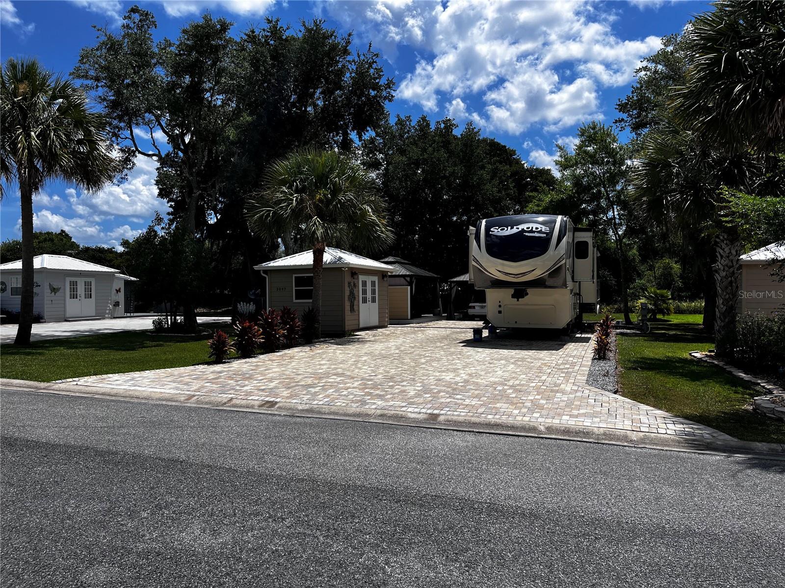 Private and peaceful with no rear neighbors, this incredible RV lot in the 55+ Wilderness RV Resort offers a rare combination of privacy, upgrades, and location. Directly across from the private clubhouse and pool, the lot is beautifully finished with pavers, decorative rock, and lush landscaping. Enjoy two separate 12x16 gazebos—one set on a 12x30 Trex composite deck—perfect for entertaining or unwinding. The covered outdoor area with half walls and electric outlets creates a comfortable space to gather with friends and family. The fully insulated shed is equipped with 60-amp service and a Mitsubishi mini-split system—making it easy to convert into a guest suite. This resort-style community sits along the Ocklawaha River and allows short- or long-term rentals, with no age restriction for ownership (just not full-time living under 55). You’ll love the feeling of being immersed in nature, yet only 7 miles from downtown Ocala via Hwy 40. Kayak from Silver Springs and pull out right at the resort! Nearby adventures include off-road Jeep trails and state parks like Rainbow Springs and Salt Springs. The resort offers a heated pool, fitness center, clubhouse, billiards, walking trails, and fishing docks. Families can visit too—grands are allowed two weeks at a time. Whether you're looking for a weekend escape, a winter retreat, or an income-generating rental, this lot delivers the best of Florida outdoor living.