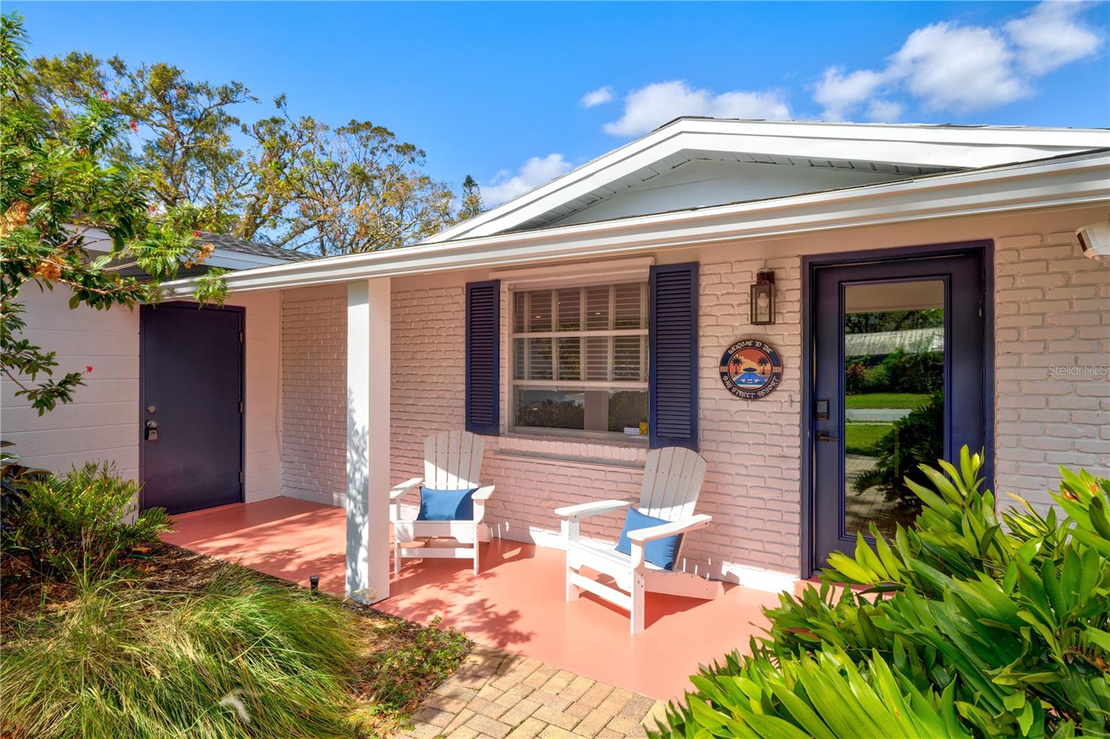Welcome to The Bay Street Resort!! This designer 3 bedroom 2 bath home sleeps up to 10 guests & is walkable to the Legacy Trail, Payne Park, the Bay St Publix and the East end of Main Street. The property was professionally renovated & furnished with vacationing guests in mind. The bright open floor plan offers an open living room, dining room & foyer seating area that allows you to see & participate in the conversation from all sides of the open space. The split bedroom layout offers great privacy with the first bedroom "the kids room" located just off the living space behind glass french doors. This room alone can accommodate up to 6 overnight guests with a twin over queen bunkbed, a standalone twin bed & a pullout queen sleeper sofa. All beds & sofa have views of the palm tree lined backyard & a 60" wall mounted smart tv. The guest bedroom offers a queen bed, built-in desk, 2 closets & a wall mounted smart tv. The master suite features a king bed, en suite bathroom & an entire hallway of closets. Conveniently, the master bath and closet hallway can be closed off to the kitchen area w/ a locked door or can be left open & function as the pool bath depending on the needs of the group. A separate guest bath next to bedroom 2 can be used as a shared bathroom for bedrooms 1 and 2 &/or the rest of the house. The living room offers seating for up to 6 guests on a genuine leather sectional facing a 65" smart tv. The foyer seating area adjacent to the living room offers views out to the front from two leather chairs and is a great place to read or sip morning coffee. The dining area offers seating for up to 8 guests & makes a great space for meals, board games, & conversation. The huge U-shaped kitchen features stainless appliances & a breakfast bar w/ seating for 3. There is ample counter & cabinet space & it's well stocked w/ all the essentials. A separate breakfast nook offers additional seating for 4 w/ fabulous pool views. 2 workstations adjacent to the breakfast nook allow for remote work while taking in views of the pool. A large laundry room w/ storage cabinets round out the interior of the home. You will know your on vacation the moment you step out back to the resort style pool & spa. The 30ft by 15ft salt water pool features a pebble tec surface, an in ground spa with soothing waterfall feature and a 15ft wide sun shelf w/ in-pool loungers, side table, & umbrella. The perimeter of the pool is lined w/ white limerock which is sandwiched between a pitch apple privacy hedge & the paver pool deck. The yard showcases five 20 foot tall Foxtail Palms that are up-lit at night for a dreamy resort vibe. A Celebrity Green custom putting area provides both ambience & fun for kids & adults. There are 4 commercial grade loungers facing South to meet all of your vitamin D needs.
A covered structural cabana provides all day shade to the gorgeous outdoor kitchen & poolside bar w/ seating for 4 more. The kitchen is centered on a 60" mounted smart tv and features a built-in 4 burner grill, a commercial grade refrigerator, an overhead fan and ample cabinet and counter space. This is the ideal spot to watch a ball game or have a cocktail while keeping eyes on the pool and putting area. An adjacent dining area offers outdoor seating for 8 under a 9ft market sunbrella.Turn the corner to find a private seating area for 4 centered around a propane fire table.This property is truly a private oasis just minutes from Sarasota's best beaches and amenities.