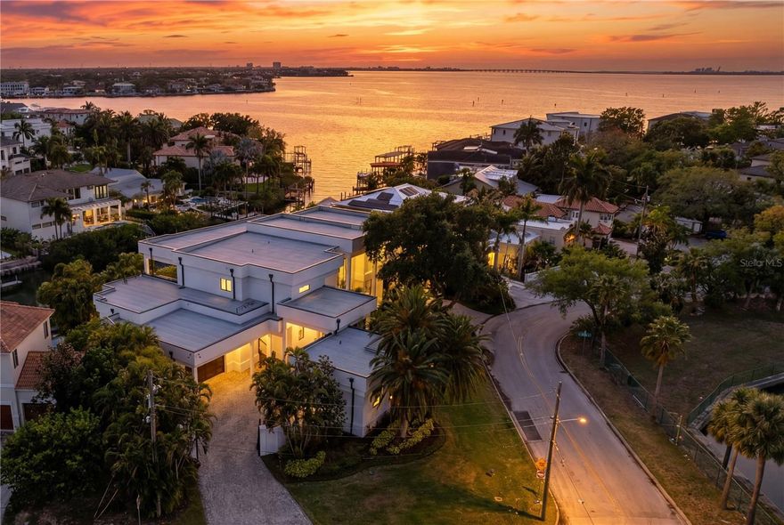 Welcome to this rare, gated waterfront estate situated on a double lot in the coveted Beach Park neighborhood. This all block, architectural wonder built by Alvarez Homes offers timeless elegance and modern luxury across 9,000 square feet of meticulously designed living space. Revealing an impressive layout that features six bedrooms and eight bathrooms, this residence also showcases a separate detached guesthouse and full bath that provides additional sleeping quarters and income potential. 
From the moment you enter the grand foyer, you are greeted by a breathtaking indoor floor to ceiling waterfall and graceful winding staircase, setting a serene tone that continues throughout the home. Designed for both entertaining company and everyday comfort, this residence includes soaring ceilings, an expansive living and dining area, and a light and bright kitchen with quartz counters, Sub Zero appliances and windows facing west that overlook the water. There is an enormous kitchen island with storage on either side that is perfect for serving family and guests. The walk-in pantry works like a back kitchen offering an extra refrigerator, microwave, and ample shelving providing additional food storage. A temperature-controlled glass wine cellar is perfect for the wine enthusiast. 

 

Showing off its impressive floor plan, this home boasts three unbelievably large owner’s suites with attached en-suite bathrooms. Two of the owner’s suites are located on the first floor, on either side of the home, providing full privacy. The third owner’s suite is on the second level offering unparalleled flexibility for multigenerational living or hosting company in style. Three additional bedrooms and two attached baths are located upstairs and can be easily accessible using the home’s elevator. Back on the main floor, there is a separate office with French doors and built-in cabinets, as well as a flex room with pilates flooring for the ultimate home gym, yoga studio or playroom.

 

A large living room slider provides easy access to the outdoor kitchen with a gas grill, pizza oven, flat top cooker, refrigerators and beer tap where your guests can lounge and relax by the pool and spa. The attached dock and covered slip provide ample room for your boat with open access to the bay and gulf, perfect for embracing Tampa’s waterfront lifestyle. 

 

The exterior is equally impressive, featuring mature landscaping enhanced by elegant lighting, a low-maintenance turfed backyard, and a stately circular paved driveway behind a secure double gated entry. The west-facing frontage captures spectacular sunset views, bathing the home in warm, golden light each evening. The detached private guesthouse provides additional accommodations for visitors, nanny or staff, while recent upgrades—including new AC units, a new roof, and whole house and lighting automation—offer peace of mind and modern efficiency. 

 

Ideally situated just minutes from Tampa International and a private jet airport, I-275 and the Veterans Expressway, this home offers unmatched convenience to Tampa’s premier hospitals, shopping, dining, Raymond James Stadium, Benchmark Arena, top-rated public and private schools and is only a block away from the grocery store allowing the home to blend luxury living with everyday ease. This is more than a home—it’s a statement of lifestyle, sophistication, and waterfront excellence. Come and see this beautiful property.  It’s ready to welcome you home!