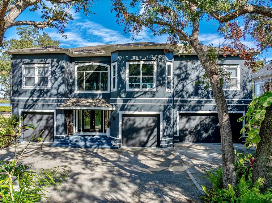 Welcome to your very own slice of paradise in charming Safety Harbor! This exceptional 4-bedroom, 3 and a half-bathroom waterfront estate offers an unparalleled lifestyle with 250 feet of direct frontage on the sparkling waters of Old Tampa Bay. Nestled on a beautifully landscaped lot, this home boasts incredible outdoor living, luxurious amenities, ultra-high-end finishes, and space for the whole family—including a private studio-style in-law suite with a full kitchen on the lower level.  Stepping through the large double doors, you’ll walk inside to a lovely two story foyer with soaring ceilings.  The in-law suite is straight ahead but the rest of the home is just up the stairs.  Style starts from the moment you walk in with polished metal handrails and a glass banister on the stairs.  Large slotted wooden doors give you a coastal modern feel along with the colors and openness of the space.  Once you climb the steps, you’ll find spacious, light-filled living areas designed to capture water views from the wall-to-wall windows.  The open-concept floorplan flows seamlessly, perfect for entertaining or relaxing in style. The kitchen is in a single word, immaculate.  Stone counters, modern cabinetry, and designer pendant light fixtures hang over the oversized island.  The backsplash is a breathtaking display of interlocking metal tiles, which goes well with the modern cabinetry.  High-end stainless Bosch appliances provide both style and function to the space.  The primary suite is a nearly 700 sq ft private oasis located through a pair of double doors off of the living room.  Elegant high ceilings, upgraded fixtures, large picture windows overlooking the water, and a sitting area highlight the bedroom itself which has a stunning sense of tranquility.  But with a step through into the bathroom, you’re in a spa-like experience that is unrivaled.  Stone counters, a modern soaking tub, and an oversized walk-in shower.  That alone would take your breath away but we’re not done.  On the other side of the bathroom is the walk-in closet complete with wall-to-wall, floor-to-ceiling custom shelving, an island/dresser with display drawers, and two windows for added natural light.  Rounding out the main level are two more well-appointed bedrooms that also do not skimp on style and share a jack-and-jill style bathroom.  The bedrooms are on a split plan to allow everyone privacy and quiet at the end of the day. You will find a half bath and laundry room located on this level as well.  Head back downstairs and enjoy the screened-in pool and spa, where a large pavered lanai with multiple seating areas invites you to unwind and soak up the serenity. Whether you’re hosting a sunset gathering or enjoying a quiet morning coffee, the expansive gazebo overlooking the bay is the perfect backdrop.  For the boating and fishing enthusiast, the private dock includes a water supply and 4-point mooring—ideal for casting a line or it can be modified for launching your kayak. And with more than five garage spaces, there’s plenty of room for vehicles, water toys, conversion to the ultimate mancave, craft room, or even a workshop.  All this in a quiet, desirable area just minutes from downtown Safety Harbor, Philippe Park, Clearwater, and world-class dining and amenities. Don’t miss this rare opportunity to own a one-of-a-kind waterfront property where every day feels like a vacation.