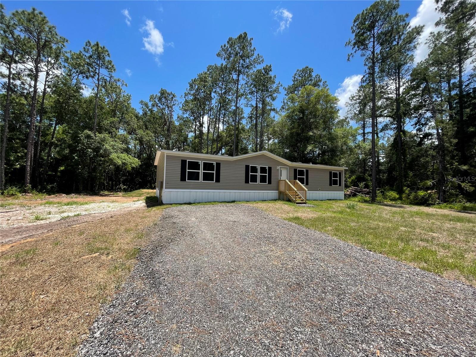 Brand New Double wide on 1.5 acres. 4 bedrooms/2 baths, kitchen island for extra cooking space, storm door, master bedroom has a walk in closet, home is situated on a concrete pad and has plenty of room for your toys! Pure serene environment, corner lot with lots of room to add a pool, shed or whatever else your hear desires! Within about 20 minutes of the beach, shopping, schools, Palm Coast, St. Augustine and about 1 1/2 from Orlando.