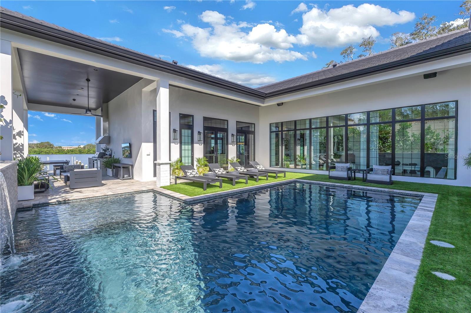 Timeless sophistication and pure luxury define this SINGLE-STORY one-of-a-kind custom waterfront home in St Petersburg.  Designed to be a forever home, you will marvel at the fine craftsmanship and elevated finishes throughout.  A vaulted ceiling open-air living room greets you to this three-bedroom, three-bathroom, and 2 half-bathroom home. Constructed to the latest codes, this all-block construction home with a tile roof and whole-house natural gas generator stands resilient to Florida weather remaining unscathed from the recent storms (no flooding in home, garages, or pool).  Enjoy expansive and unobstructed waterfront views from the open-concept kitchen and living room adorned with custom glass windows and doors to allow an abundance of natural light.  The pool is extremely private and leads to an outdoor kitchen and back patio overlooking Coffee Pot Bayou.  Lastly, the dock with a 10,000 pound boat lift is extremely durable and constructed with DECKWEAR that is cool to the touch even on the hottest days. Just minutes to the Vinoy Golf Course, the Coffee Pot Bridge, and downtown St Petersburg the ultimate lifestyle is right there for you to enjoy.