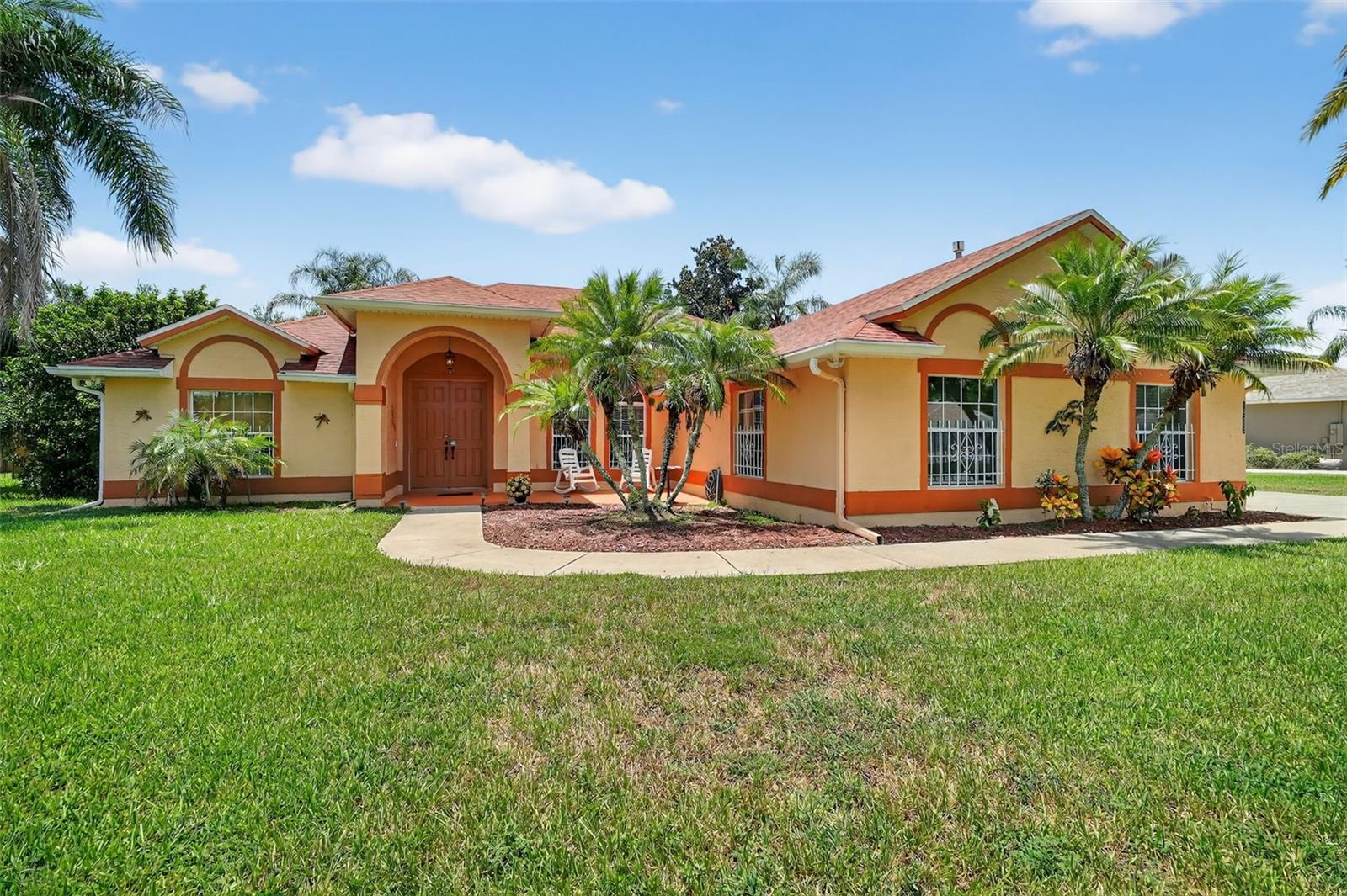 Situated on a generous .45-acre lot, this 3-bedroom, 2-bath pool home with a rare 4-car garage offers space, privacy, and modern updates. A new roof (2021), new HVAC (2024), and new hot water heater (2024) mean you can enjoy peace of mind from day one. The tiled entryway opens to an inviting living room with a gas fireplace, crown molding, and double doors leading to the sparkling pool. The split floor plan provides privacy, with a primary suite featuring a walk-in closet, en suite bath with jetted tub, separate shower, and dual vanities. The kitchen includes bar seating, an eat-in breakfast area, gas stove, and stainless steel appliances, with a formal dining room nearby for special gatherings. Outside, the screened saltwater pool features a tranquil waterfall and spacious covered lanai, all overlooking a private backyard perfect for relaxing afternoons or entertaining guests. Low HOA of just $165 a year completes the package.
