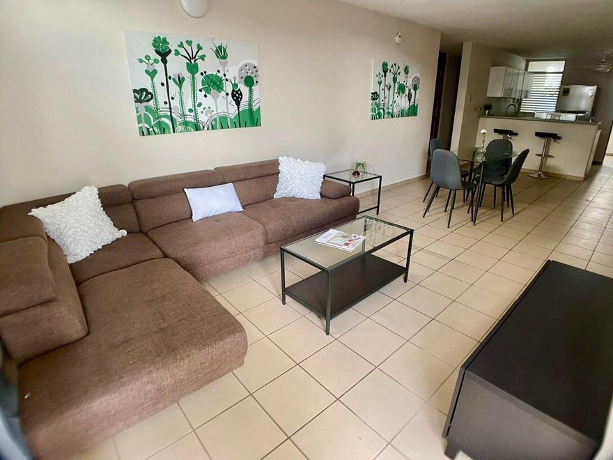 Fully furnished and equipped corner apartment for rent in Ponce, available starting July 1st. This move-in ready property offers an ideal combination of comfort, functionality, and a strategic location. It features three bedrooms furnished with beds, nightstands, and air conditioning, a modern bathroom, a balcony, a living room with comfortable furniture, and a dining area for four. The kitchen is equipped with a stove, refrigerator, and washer/dryer combo. Private parking with controlled access is included. Additional features include air conditioning in the living room, a ceiling fan in the kitchen, and maintenance is included in the monthly rent. The complex offers security cameras, controlled access, a shared patio area, and a water cistern. Its excellent location provides quick access to the Law School and is just 7 minutes from Ponce Health Sciences University, as well as supermarkets, hospitals, schools, and medical offices.