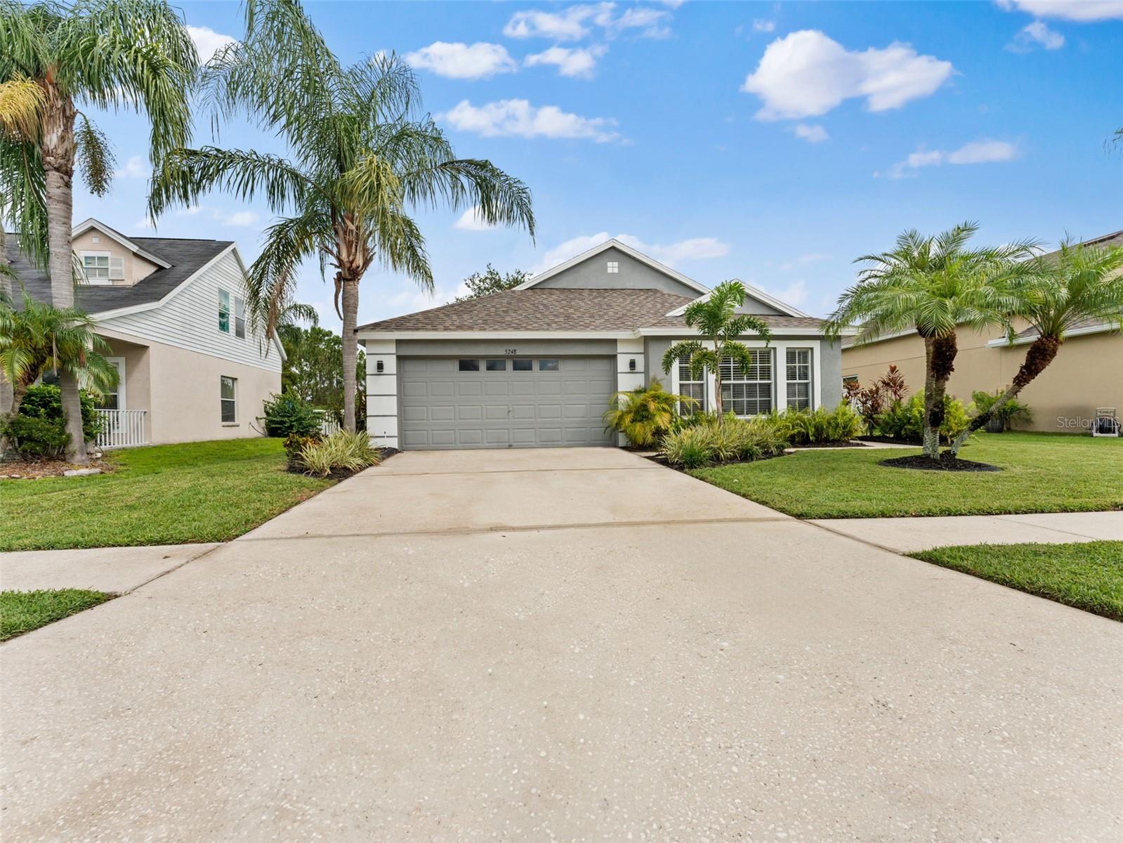 Welcome to New River Lakes in highly sought after Wesley Chapel. This waterfront home in The Estates features a spacious fenced yard suitable for gardening, a swing set, and more. This well-maintained home includes 3 bedrooms, 2 bathrooms, a 2-car garage, a combined living and dining area, a bonus room, an indoor laundry room, and a 15x9 covered back patio. Upon entering the home from the covered front entry, you will be greeted by a gorgeous and peaceful view of the lake, lush lawn and landscaped backyard. The kitchen is open to the living room and dining area making family time and gatherings easy and enjoyable. There is a 13x16 separate bonus/family room that would also be perfect for a formal dining room, office, playroom or theatre room. This is an open and split bedroom floor plan. The master suite showcases a beautiful professionally applied Anthropologie wallpaper mural, sliders to the back patio, walk in closet, a master bathroom with a dual sink vanity garden tub with shower and new flooring. The inside laundry room includes shelving and the washer and dryer 2021. There is lots of room to cook in this kitchen which includes an added butcher block counter, closet pantry and a new refrigerator and dishwasher. The fenced backyard overlooking the lake is the place to be with new sod Fall 2024, a family gathering area, privacy fenced sides, covered paver patio and a mature oak tree providing the perfect amount of shade. Features include AC (2021), roof (2021), exterior paint (2022), LVT flooring, new toilets (2023), blinds, ceiling fans, interior paint by professionals, irrigation and freshly mulched landscaping beds. No CDD and the low HOA includes access to the community pool, playground, basketball courts, tennis courts and Spectrum cable and internet. This area is booming with new developments, hospitals, shopping, entertainment, schools and recreation. Great location with easy access to Hwy 54 and I75. This move in ready and well cared for home is ready to welcome you to your new home.