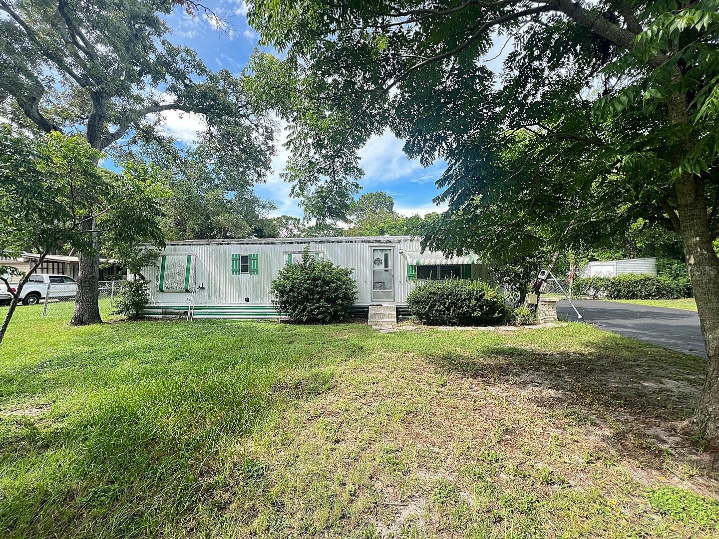 Incredible Redevelopment Opportunity! This spacious .62-acre fenced lot offers dual access from Ray Street and Kent Street, providing flexible options for future development. The property includes an older mobile home in fair condition — while it may be salvageable with repairs, it's likely a tear-down, perfect for starting fresh. The lot features an inground pool, three storage sheds, and ample space for your vision to take shape. Whether you're looking to renovate, replace, or build new, this versatile property has the potential to shine. The power pole was damaged in last years hurricanes, so there is no power to the home. Utilities will not be restored. This is an AS-IS Sale..