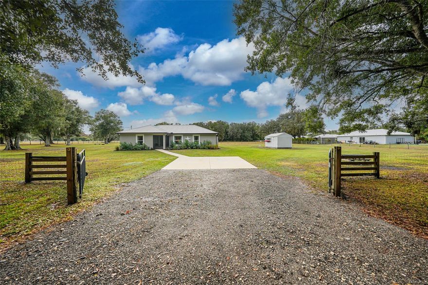 Set on three peaceful acres just minutes from downtown Arcadia, this 2020-built concrete block home feels practically brand new from the moment you arrive. The gated entrance welcomes you in, and the entire property is fully fenced with an additional privacy-fenced back yard, creating the perfect setup for animals, outdoor living and a little slice of quiet all your own. Inside, the home opens with vaulted ceilings, an airy open floor plan and a split layout that gives everyone space while keeping the heart of the home connected. Because it was built in 2020 and immaculately maintained, everything here still has that crisp, like-new feel. The kitchen is gorgeous with its large island, stainless steel appliances, closet pantry and smooth flow into the dining area. From there, sliding glass doors lead you right onto the back patio where you can enjoy calm evenings and morning coffee with the sounds of country life. The primary suite is generous in size with a walk-in closet and a custom upgraded bathroom that feels like a personal retreat. Two additional bedrooms offer comfort and flexibility for family, guests or your favorite hobbies. If you’ve been dreaming of a modern home that’s move-in ready, like new, and sitting on land where you can truly live the lifestyle you want, this Arcadia acreage is ready to welcome you home.