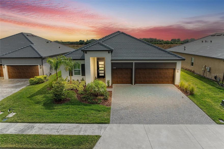 Opportunity to bypass the build process and start living a life well deserved life!  Welcome to Prosperity Lakes, where this better-than-new Eventide floor plan delivers single-story living with exceptional upgrades throughout. Featuring 3 bedrooms, 3 full baths, and a rare three-car garage, this home is thoughtfully designed for modern comfort and flexibility.
The open-concept layout seamlessly connects the kitchen, dining, and family room, creating a bright, inviting space that opens to a private screened-in lanai—perfect for relaxing or entertaining. A versatile flex room adds functionality, while all bedrooms are privately situated, including a lavish owner’s suite with a beautifully customized walk-in closet and spa-like bath.
This home truly shines with its extensive upgrades, including high-end appliances—a Samsung Bespoke refrigerator, LG dishwasher, and Empava gas range—along with crown molding, a porcelain kitchen backsplash, luxury vinyl plank flooring in bedrooms two and three, and luxury wood plank flooring in the primary suite. The laundry room is fully outfitted with cabinetry above the Samsung top-load washer and dryer, additional base cabinetry, and a granite countertop. Extended shelving in every closet adds smart storage, and the custom primary closet elevates everyday living.
Car enthusiasts and hobbyists will appreciate the insulated garage doors, mini-split AC system in the garage, and abundant overhead storage, making the three-car garage both functional and comfortable. The home has also been recently painted inside and out, offering a fresh, move-in-ready feel.
Prosperity Lakes offers resort-style amenities including a clubhouse, fitness center, resort pool with waterslides, pickleball, tennis, bocce ball, playground, and walking trails. Additional 55+ perks include a full-service kitchen and bar, yoga studio, and curated event programming designed for an active, social lifestyle.
Luxury, upgrades, and lifestyle—this one truly checks every box.