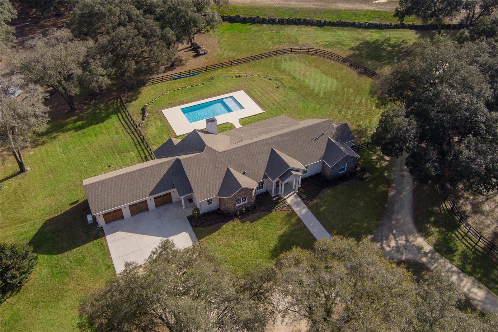 Less than 10 miles to the WEC, across the street from HITS, and in the heart of some of NW Ocala's finest horse country, is this 27.5+ acre gem! Barn 1 features 16 12x12 stalls with new Amberway interlocking mats and individual stall fans; there are an additional 4 stalls with rubber mats and auto waterers. The recent upgrades include new stall doors, Shoo Fly bug system, security cameras, and LED lights. Also included are an office, tack room (can be converted to apartment), full bath, feed room, washer and dryer, and wash racks with hot water. The 4-stall #2 barn has auto waterers, large fans over the stalls, 2 storage bays, hay storage, and an enclosed shop area. The 6 paddocks and 3 pastures have waterers, and beautifully-maintained new board fencing. There is a regulation-size irrigated dressage arena with all-weather footing, mirrors, and a screened viewing gazebo. There's an additional large sand training arena and 2 RV hookups. The beautiful main home features two master suites, both having outside access to the back patio and pool area. A large island chef's kitchen makes cooking a breeze for a crowd of any size, and includes a large walk-in pantry. The 2021 saltwater pool is just the place to cool off after a long ride. There's a 2 BR guest home next door beautifully finished with eat-in kitchen, and jack and jill bathroom. This beautifully equipped farm is perfectly suited for any discipline.