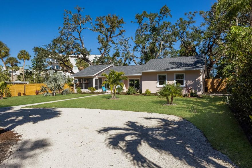 IF YOU LONG TO BE IN DOWNTOWN SARASOTA BUT CONDO LIVING IS NOT YOUR THING, YOU MUST LOOK AT THIS OPPORTUNITY AVAILABLE TURNKEY FURNISHED IMMEDIATELY. This 3-bed-2-bath home is in Tahiti Park, one mile north of downtown Sarasota and adjacent to Centennial Park and The Bay Conservancy, Sarasota’s developing 53-acre bayfront park. You will feel like you’re walking into a new home with most of the work completed in 2022 and 2023. This includes a NEW ROOF, IMPACT RESISTANT WINDOWS, reinforced stucco siding, flooring throughout, kitchen, baths and more! The screened front porch looks over the spacious, serene front yard shaded by ancient oaks. Inside, the open plan is light and bright with high ceilings, transom windows and ultra smooth walls (no texture!). The kitchen and dining area are anchored by a large island big enough for a party of 6. Engineered hardwood flooring and recycled glass counters unite this space in complete harmony. The owner’s suite has 4 closets (!) and a luxuriously updated bath with dual vanities and a walk-in shower.  The two additional bedrooms share a bath with a zero-threshold shower. The 3rd bedroom has a private entrance and access to the laundry room allowing guests and visitors to come and go privately or a perfect spot for a home office. The front porch and patio will be where to watch the sunset, but you’ll also find two back yard, paver patios providing additional areas to enjoy the mature landscaping and the privacy of a completely fenced yard.  A rear load garage is accessed by Lowe Lane, a private road used only by 5 homeowners.