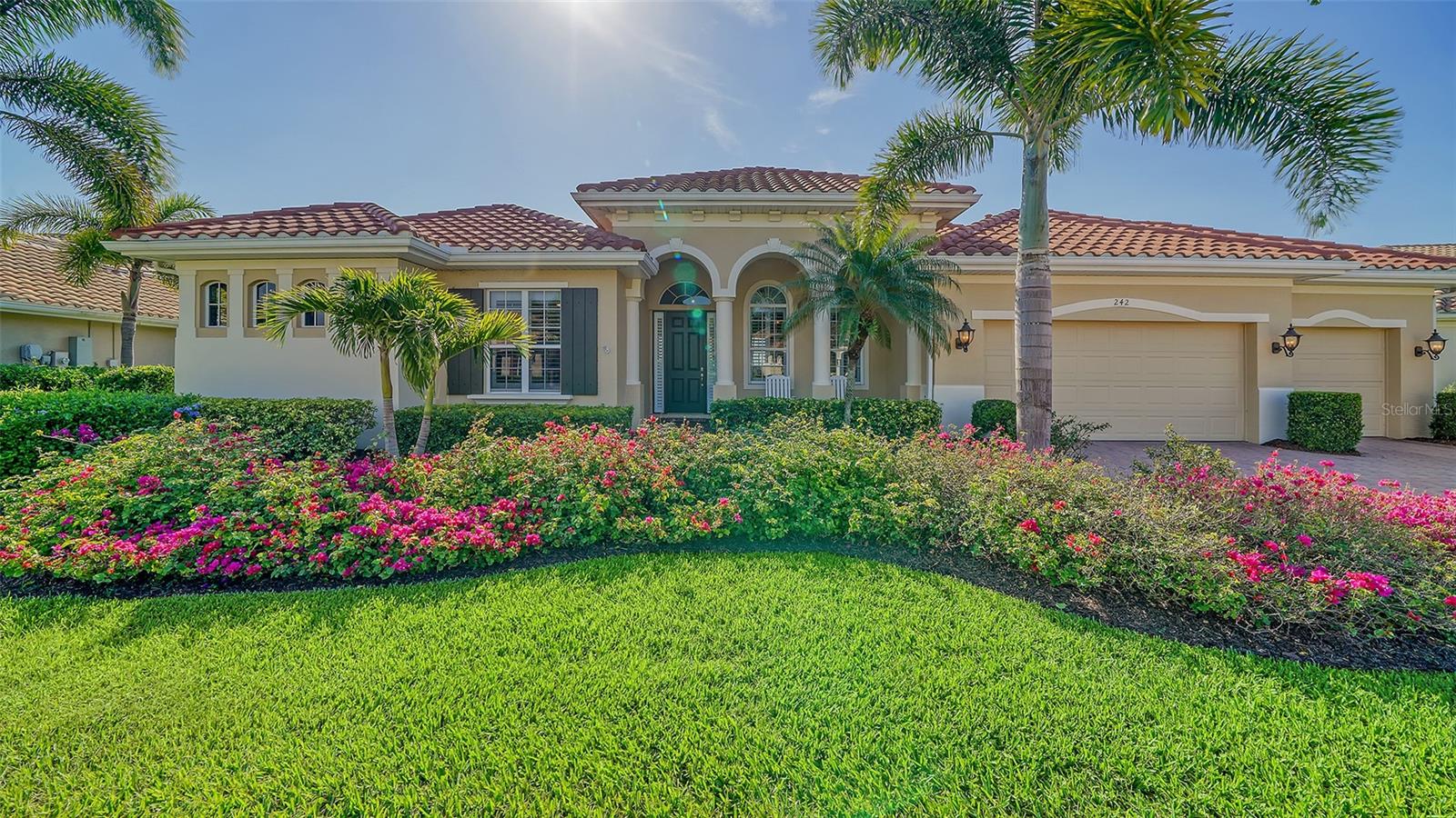 This is a WOW! You will ooh and ahh when you enter this elegant home. Prime lakefront lot with expansive views. The infinity saltwater pool literally flows into the lake and is heated with solar, gas & electric. The chef’s kitchen features granite counters, island, breakfast bar, eat-in kitchen area with aquarium window, 6 burner gas stove top, Advantium oven/microwave, convection oven and warming tray, separate ice maker, 42” side-by-side refrigerator, two Bosch dishwashers. All bedroom closets have custom wood shelving. Master bedroom offers an additional sitting/exercise area. Master bath boasts a Jacuzzi tub, dual shower heads, double sinks & tile accents. The Den/library has gorgeous wood built in book cases. You will enjoy all the columns, crown molding, high end ceiling fans, tray ceilings, central vac, beautiful wood flooring, plantation shutters, hurricane shutters or impact windows throughout plus a whole house Generac gas generator with warranty. Barn door separates 2 of the bedrooms and bath. Upgraded A/C unit with air scrubber, electronic Air filtration system, & UV Bulb. Omnilogic Pool control system plus an autofill system. Whole house power cleaner and surge protector. 3 car garage with epoxy coating will hold all your toys & overhead storage. 24/7 security guard at gate. The golf club membership is separate and not required. Including a heated pool, a lap pool, tennis courts, fitness courts, restaurant and boardwalk down to the river. CDD fee is included in the tax amount. Minutes to beaches shopping, banking, restaurants & more. Truly a must see.