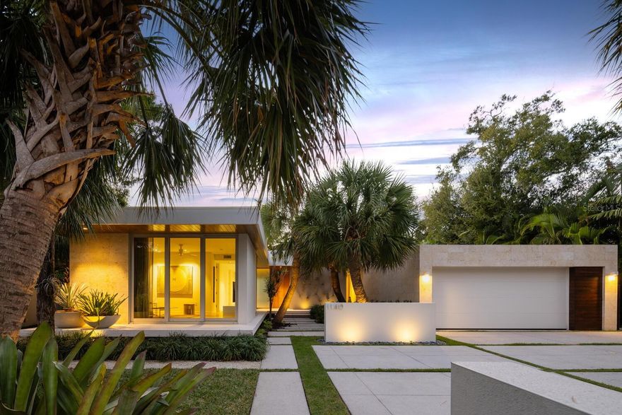 Welcome to 1140 Citrus Avenue, located in the historic Hudson Bayou neighborhood near downtown Sarasota. First time on the market, this award-winning residence designed by architect Chris Leader was voted in 2018 Platinum Best Overall Home of the Year, Platinum winner for Best Landscape, Platinum winner Sustainability|Green Award, Platinum winner Best Kitchen, & Platinum winner Best Great Room. The home has achieved the National Green Building Standard’s Gold certification. This near downtown location cannot be more convenient to the urban lifestyle afforded by its proximity to Palm Avenue with boutiques, restaurants, Marie Selby Botanical Garden, and Sarasota’s bayfront—all within walking distance. Plus, a mere half mile to Southside Village's coffee shops, boutiques, gourmet food market & restaurants galore to delight the senses. The owners worked closely with the architect to create this warm, modern, sophisticated home designed around magical Zen gardens. The home achieves a respectful context within the neighborhood, while providing privacy for the residents. Meandering east to west across the length of the 20,000 sq ft double lot, the home wraps around a series of courtyards. Each room offers a unique vista of the gardens, designed by landscape architect, David W. Young. The cantilevered entry's courtyard features carefully placed curved sabal palms, plantings, and a concrete stepping stone path leading to the front door. Guests enter into a gallery space and are greeted with an enchanting long view across the pool courtyard. This is a “wow” moment as the eye is drawn to a water wall, painted a vibrant Luis Barragan pink, which serves as the focal point of the pool courtyard. The living room features 13-foot ceilings & west-facing clerestory windows to capture colorful sunset sky views. Floor-to-ceiling glass faces the pool courtyard and a backdrop of dense plantings providing privacy. This is the heart of the home, providing a place to pause and reflect on the surrounding beauty. The kitchen opens to a deep porch with large overhang, providing shade from the southern sun. White kitchen cabinets wrap the perimeter while the center island is wrapped in rift cut white oak. A marble backsplash and back-painted glass upper cabinets provide timeless accents. The dining area is enveloped by its own dreamy views of the north gardens and landscape lighting illuminating specimen plants. The owner’s wing opens to both a private meditation garden and the pool courtyard. There are separate bathrooms, one with the shower and tub placed to allow views of the meditation garden, connecting visually between indoor and outdoor spaces. A guest suite with a secluded outside sitting area is accessed from the pool courtyard. A den at the front of the home can serve as a 4th bedroom, and opens to the entry courtyard and front porch, providing an intimate space to relax. There are two offices, both with views to the pool and gardens. A warm palette of materials is used on both the interior and the home's exterior. The exterior Cypress wood detailing and Coralina Shell Stone cladding provide a rich contrast to the smooth white walls of the interior. With first class quality construction lending to the timeless appeal of the entire experience, it's as if the home was completed just yesterday. Don’t wait to see this magnificent property; you will come away with a feeling of enchantment. This just may be your next home.