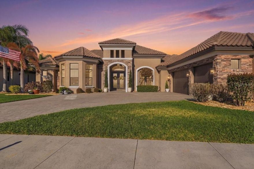 Experience refined lakefront living in this exceptional 3-bedroom, 3-bathroom custom pool home by Arthur Rutenberg Homes, located in the highly sought-after Lake Juliana Estates, 2020 Parade of Homes Community of the Year. Perfectly positioned on Lake Tennessee, a well-known destination for premier water-skiing featuring slalom courses and a jump, this property offers approximately 1.44 acres (inc. submerged land) and features 90 ft. of private dockage complete with a 6,000 lb. covered boat lift, delivering the ultimate waterfront lifestyle. From the moment you arrive, the home makes a lasting impression with its elegant stone façade, manicured landscaping, expansive paver driveway, and a three-car extra-length garage with an added golf cart door, providing ample space for vehicles, storage, and recreational equipment. A covered entry leads to a stunning double-door entrance with custom ironwork, opening to an interior where breathtaking lake views immediately take center stage. The main living areas are designed to impress, featuring 12-foot ceilings, hand-scraped hardwood flooring, detailed crown molding, and custom millwork. Oversized sliding pocket glass doors flood the space with natural light and seamlessly connect indoor and outdoor living. The open-concept layout allows the living room, dining area, and kitchen to flow effortlessly ideal for entertaining or everyday comfort. Step outside to the expansive paver pool deck and enjoy serene water views alongside the soothing sounds of the pool. The gourmet kitchen is both stylish and functional, offering granite countertops, custom Kitchen Craft cabinetry, a copper farmhouse sink, gas stainless steel appliances, dual-zone wine cooler, reverse osmosis system, and a spacious hidden pantry. The split-bedroom floor plan ensures privacy, with two bedrooms featuring its own en-suite bathroom and walk-in closet. The third bedroom is fully soundproof, perfect for a media room or studio. A dedicated office with French doors and tray ceilings provides an ideal work-from-home space, while a versatile den/bonus room offers flexibility as a potential fourth bedroom. Plantation shutters are installed on the west-side bedrooms /rooms, enhancing energy efficiency & comfort from afternoon sun exposure. The owner’s suite is a private retreat, featuring tray ceilings, stunning lake views, direct pool access, and dual walk-in closets. The spa-like en-suite bath includes a custom copper soaking tub, oversized walk-in shower with dual shower heads, and dual vanities with ample space.
Outdoor living is equally impressive, featuring a heated saltwater pool with an integrated jacuzzi, a variable speed pump, and an inviting outdoor living room complete with a gas fireplace—perfect for year-round entertaining while enjoying tranquil lake views. The fully fenced backyard includes pet access, while the property’s direct lake frontage offers an extended dock system and covered boat lift, ideal for enjoying one of the area’s premier watersports lakes. Highlights include a 500-gallon underground propane tank supporting the home’s gas features, along with energy-efficient upgrades such as R-30 insulation, radiant barrier roofing, a smart temperature control system, and a tankless gas water heater. This meticulously maintained, move-in ready home presents a rare opportunity to own a premier lakefront property with acreage, privacy, and luxury finishes in one of the most desirable gated communities.