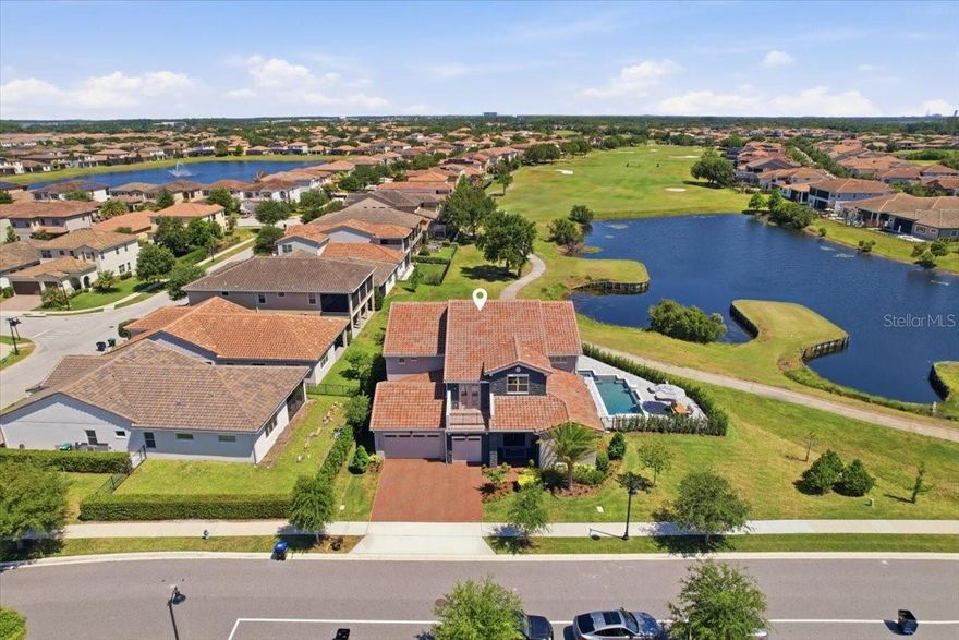 Experience elevated living in this exceptional luxury home, perfectly positioned on the golf course with a water view within the gated community of Eagle Creek Golf Club. Situated on a private 1/3-acre lot with breathtaking views, this extensively upgraded residence blends timeless elegance, modern sophistication, and resort-style amenities.

Step inside to discover stunning new flooring throughout, featuring hardwood-look tile on the first floor and rich hardwood flooring upstairs. Designed with both entertaining and everyday comfort in mind, the home showcases an impressive wine room and a fully custom bar complete with an ice maker, beverage drawers, and a dedicated glass-cleaning sink conveniently located off the dining room.

The gourmet kitchen is a true showpiece, featuring custom cabinetry extended to the ceiling, a designer vent hood, built-in pantry storage, all-new Thermador appliances, and striking modern pendant lighting. The spacious living room is anchored by a dramatic stone fireplace, creating a warm yet sophisticated gathering space, while custom wall treatments throughout the home add another layer of luxury and design.

The first-floor owner’s suite is a private retreat featuring a stunning double-sided fireplace that flows into a spa-inspired master bathroom with an oversized glass shower, separate soaking tub, and expansive custom-designed walk-in closet with built-in storage.

A beautifully appointed library offers custom built-in shelving with a rolling ladder, providing the perfect retreat for work or relaxation. Upstairs, a large loft area creates the perfect secondary living and entertainment space, complete with counters, pantry storage, dishwasher, and a panel-style refrigerator. Additional wellness-focused features include a private sauna with a dedicated spa bath and a spacious room structurally designed to accommodate a future home gym.

Seamlessly blending indoor and outdoor living, expansive sliding accordion doors open to a screened and covered patio featuring a newly built outdoor kitchen with a grill, warming drawer, sink, and abundant storage. Elegant pavers lead to the large fenced pool and spa surrounded by luxurious marble decking, while mature privacy shrubs create a secluded backyard oasis overlooking the golf course. An additional screened upper-level porch captures stunning panoramic views of Hole 15.
Additional highlights include permanent exterior lighting and an oversized 3-car garage with epoxy floor coating.

This extraordinary residence offers unmatched craftsmanship, luxury finishes, and exceptional indoor-outdoor living make your appointment to see this unique property today.