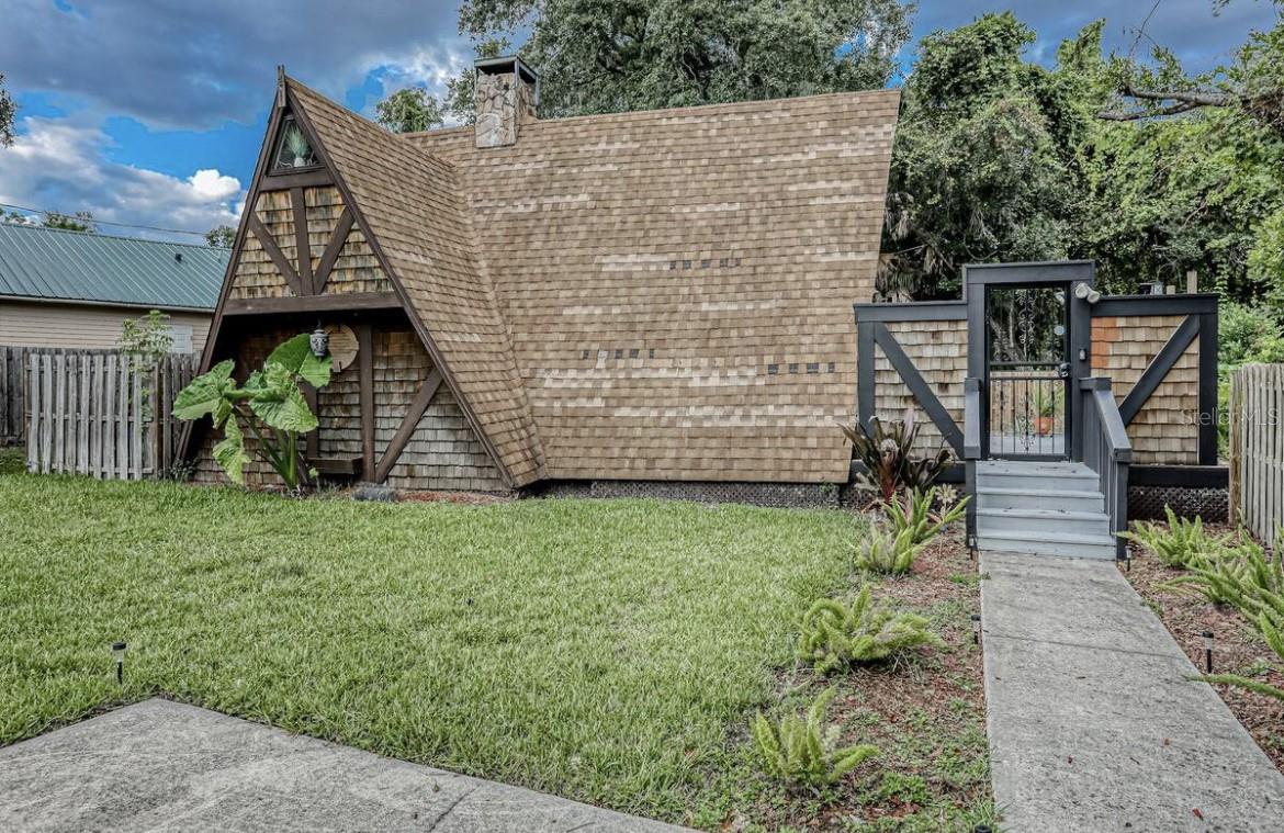 Whether you're looking for a weekend getaway, full-time residence, or unique short-term rental opportunity, this home is more than a place to live — it’s an experience. Discover a rare gem: This striking A-frame home blends modern design with rustic elegance, creating a one-of-a-kind retreat nestled in nature. With its iconic architecture and expansive windows, this property offers a seamless connection to the outdoors, bathing every room in natural light and showcasing stunning views year-round. Step inside to find soaring vaulted ceilings, warm wood finishes, and an open-concept living area that feels both expansive and inviting. At the heart of the home, a sleek wood-burning fireplace adds cozy character, while wide-plank tile flooring and exposed beams bring timeless texture and warmth. The kitchen is thoughtfully designed for both form and function, featuring matte grey cabinetry, solid stone countertops, open shelving, perfect for entertaining or everyday living. Ascend the custom staircase to the open loft — an airy, versatile space overlooking the main living area, ideal for a primary bedroom, home office, or creative studio. Windows above allow for stargazing from bed or basking in natural light all day long. Outside, enjoy a spacious deck for morning coffee, evening sunsets, or gatherings under the stars. Surrounded by trees and tranquility, this A-frame offers the perfect blend of privacy and style.