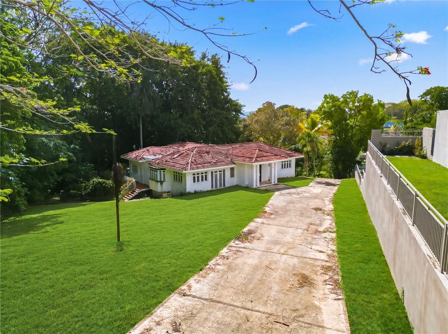 Located in one of Guaynabo’s most exclusive and private communities, this property at Calle Vanda#7 offers a rare balance of tranquility, space, and accessibility. Surrounded by nature and set on a large piece of land, the home feels like a peaceful retreat—quiet, green, and removed—yet still conveniently close to the city and major expressways.

The residence features 6 bedrooms, 5 bathrooms, and approximately 5,830 square feet of living space. It’s an ideal opportunity for a buyer with vision, ready to remodel and shape the home into something truly their own. Balconies and terraces wrap around the property, creating inviting spaces to relax, gather, and enjoy the natural surroundings.

Within a gated community with 24/7 security, this home also benefits from a prime location near some of Puerto Rico’s most prestigious schools, making it a strong choice for families. It’s a place where you can enjoy the feeling of living in the countryside, with the convenience of being right in the heart of Guaynabo.