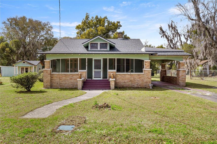 Step into a piece of old Florida history with this charming 1925 home located in the heart of Hawthorne. Full of character and timeless details, this 3-bedroom, 2-bath residence over 1,600 square feet of interior living space on a spacious ½-acre in-town lot, blending the craftsmanship of the past with thoughtful modern updates. The home welcomes you with a large 270 sqft full-length screened front porch, the perfect spot to enjoy slow mornings, evening breezes, and the peaceful charm of small-town living. Inside, you’ll find a traditional closed floor plan reminiscent of classic early 20th-century homes, where each room has its own distinct space and purpose. The front door opens into a cozy living room anchored by an original decorative fireplace, a beautiful nod to the home’s nearly century-long history. An elegant arched doorway leads from the living room into a formal dining room, creating a warm and inviting setting for gatherings and family meals. From there, doorways guide you into the kitchen, where another graceful arch reveals a built-in breakfast nook, an endearing feature that captures the charm of a bygone era. Tucked privately at the back of the home is the spacious primary suite, while the guest bedrooms and remodeled guest bathroom are situated along the right side of the house, offering a practical and comfortable layout. While the home proudly showcases its historic character, it has been thoughtfully refreshed with brand new luxury vinyl plank flooring throughout, a freshly painted interior, a beautifully remodeled guest bathroom, and new stainless steel appliances. A new roof installed in 2023 provides added peace of mind. Outside, the large backyard offers plenty of room to garden, play, or create your own outdoor retreat, complete with storage sheds for extra space and a built-in carport for covered parking. Located in the quaint and historic town of Hawthorne, this property offers the quiet charm of small-town living while remaining conveniently 20–30 minutes from Gainesville and about 30 minutes to Ocala. Homes like this—rich in history, character, and classic architectural details—are becoming increasingly rare, making this a truly special opportunity to own a piece of the past. Stop scrolling and come see this home before it's gone!