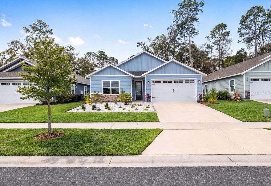 Why wait for new construction when you can move right into this beautifully upgraded home in the desirable Grand Oaks at Tower community? This thoughtfully designed 3 bedroom, 2.5 bath home offers a bright, open-concept floorplan perfect for both everyday living and entertaining. The airy living room welcomes you with abundant natural light and an elegant tray ceiling, creating a spacious and inviting atmosphere. The chef-inspired kitchen features quartz countertops, gas cooktop, a large center island with pendant lighting and eating space plus an exceptionally spacious walk-in pantry. The owner's suite is a private retreat with a tray ceiling and french doors leading to the covered lanai. The spa-like ensuite bathroom offers a dual sink quart vanity, zero-entry glass-enclosed shower with beautiful tile work and a large walk-in closet. Two well-appointed guest bedrooms with ceiling fans provide comfort and flexibility for family, guests or a home office. Step outside to enjoy the extended covered lanai overlooking a large, fully fenced backyard offering the perfect space for relaxing. Additional highlights include a 2-car garage, interior laundry room and tankless water heater. Residents at Grand Oaks at Tower enjoy community amenities including a playground, resort-style pool and cabana with seating. Conveniently located in southwest Gainesville, this home offers easy access to the University of Florida, UF Health and Celebration Pointe making it ideal for both work and leisure.