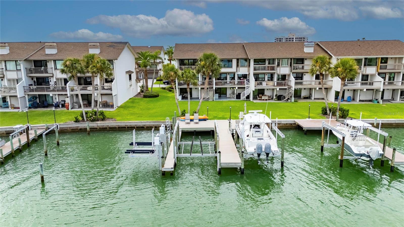 BRING YOUR BOAT AND YOUR LOVE FOR COASTAL LUXURY! This end-unit waterfront townhome in the sought-after Marina Del Rey community on Sand Key offers the ultimate Florida lifestyle with breathtaking open water views and direct boating access. Completely renovated with elegant coastal finishes, this spacious home spans three levels of versatile living space. First Floor: A flexible bonus room (ideal as a boat room, game room, or guest retreat) features a wet bar, full ensuite bath, and sliding doors to a private patio with backyard and dock access. Second Floor: Drenched in natural light, the main living level boasts a designer kitchen with white shaker cabinetry, waterfall-edge island, gleaming countertops, and top-of-the-line stainless appliances. A home office/bonus space (potential 4th bedroom) and a stylish half bath are nearby. The open dining and family rooms are wrapped in windows showcasing stunning views of the Intracoastal and marina. Third Floor: The luxe primary suite offers a private waterfront balcony, a massive walk-in closet with custom built-ins, and a spa-style ensuite bath featuring double vanities and a dramatic wet room with soaker tub and shower — all with water views. A second light-filled bedroom includes a large closet and updated ensuite with a walk-in shower. Additional highlights: Hurricane rated windows and doors. Plantation shutters, custom blinds, and electric custom blinds. Spacious laundry room, Abundant storage. New HVAC and mini split unit installed in 2024. Boaters will fall in love with the double dock with sundeck, 20,000 lb boat lift, 2 jet ski lifts, kayak lift, and TREX decking with dual-side boat access — all right in your backyard! Enjoy the heated community pool! All of this just across the street from the beach, near Sand Key Park, and a short walk to restaurants and boutiques. This is coastal living at its finest — don’t miss your chance to own a slice of Sand Key paradise!