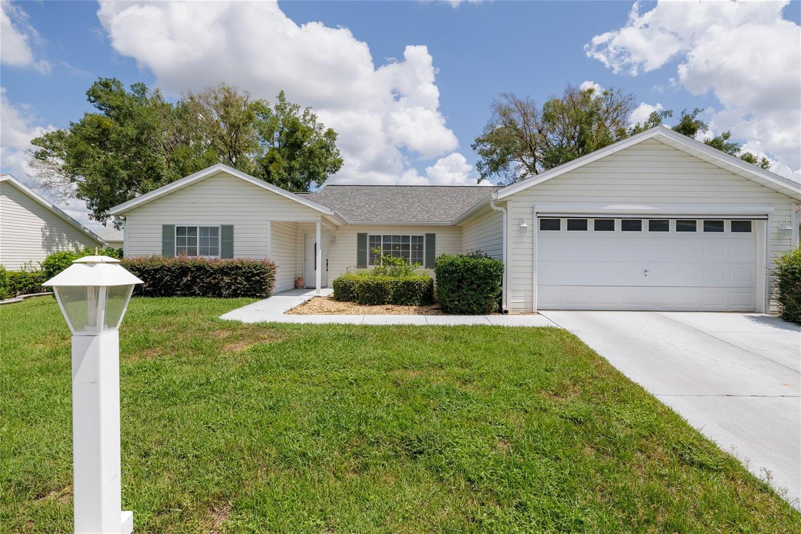 Located in the sought-after Spruce Creek Golf & Country Club, this beautifully maintained home offers over 1,800 sq ft of comfortable living space with 3 bedrooms, 2 bathrooms, and an enclosed Florida room perfect for year-round enjoyment. You’ll love the open layout, tile floors in the main living areas, soft carpet in the bedrooms, and rich wood cabinetry throughout. The home also features an inside laundry room and a professionally landscaped yard with irrigation. Enjoy the amenities of this vibrant Del Webb community—golf, pools, tennis, clubs, and more—all just minutes from The Villages and Ocala.