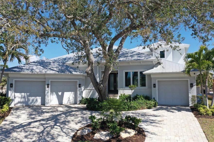 One or more photo(s) has been virtually staged. Step into the Siesta Key lifestyle today — no waiting for construction, no uncertainty, just effortless waterfront living. Elevated at 10.5 feet with no history of flood damage, this exceptionally maintained 2015 Key West–style home offers an exceedingly rare turnkey waterfront opportunity, combining timeless design with peace of mind, creating a sanctuary where every detail has been carefully considered.

Imagine mornings in your chef-inspired kitchen, quartz counters gleaming, Thermador appliances, and a gas stove ready for weekend brunches. Walls of glass invite sunlight into the great room and open to a covered lanai with outdoor kitchen, heated saltwater pool, carefully maintained landscaping, and majestic oak trees, where afternoons flow seamlessly into evenings spent entertaining family and friends. A versatile den/office provides a quiet retreat or workspace, and the outdoor shower makes rinsing off after a day on the water effortless.

Outside, a wide waterfront canal with private dock, 13,000-lb boat lift, and fish cleaning station offers direct access to the Intracoastal — perfect for boating, yachting, and all water adventures with only one bridge to navigate. The 3-car split garage provides space for a collector car, golf cart, or hobby projects, while impact windows, a whole-house generator, and updated HVAC ensure comfort, safety, and peace of mind.

The split floor plan offers privacy for guests with en suite baths, while the primary suite is your own private retreat. Nestled on a quiet cul-de-sac and WIDE canal, just minutes from Siesta Village, award-winning beaches, dining, shopping, and Sarasota’s vibrant arts scene, this walkable, bikeable, and kayak-friendly neighborhood lets you enjoy everything the Key has to offer without ever getting in your car — every day feels like a vacation.

More than a house, this is a lifestyle ready now.  Secure, elevated, turnkey waterfront property, and perfectly positioned on one of Siesta Key’s most desirable canals. Experience the rare combination of security, luxury, and effortless waterfront living — your turnkey Key West–style sanctuary awaits.