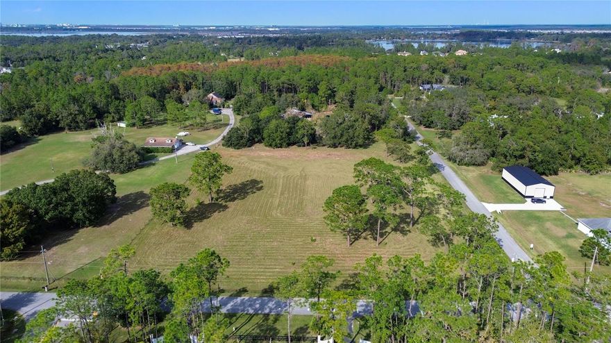 A rare offering of over six acres of prime, high & dry land—ideal for developing custom-built residences or creating a private estate in the rapidly growing Moore St corridor. The location keeps you just minutes from Lake Nona, direct back-road access to Sunbridge Park, Medical City, major highways, and everyday conveniences.
The land offers an ideal canvas for custom-built residences—ample room for generous lots, long driveways, and private outdoor settings—surrounded by attractive neighboring properties. With public water available on Moore St, the property is exceptionally well-positioned for those seeking to create a premium residential offering or design a legacy estate.
The existing home - in style with the little house on the prairie -  is a 2/2 but with upstairs flex space suitable for a third room or office, offering immediate use and/or income potential. The house is in good condition and move-in ready. 
A 28×28 barn/garage brings added versatility—perfect for equipment, materials, vehicles, or boats, or as a functional workspace. The barn features dual side bays (approx. 28×16 each), dog kennels on one side, covered storage on the other, and an interior utility room with plumbing already in place.
Large, high & dry parcels of this size and quality are increasingly scarce in the Narcoossee corridor. For developers, custom homebuilders, or buyers looking to craft an elevated residential experience, this property presents a rare and valuable opportunity in one of Central Florida’s most premium growth areas.
For additional details, please contact the listing agent.
