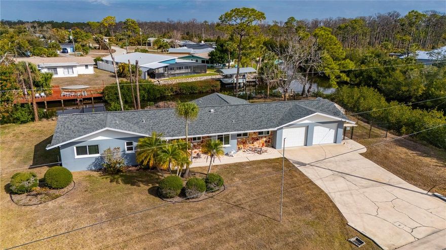 Rare Gulf-access waterfront retreat on an oversized approximately half-acre corner lot with an impressive 325 FEET OF WATER FRONTAGE, offering the private, nature-filled Florida lifestyle buyers dream about with NO HOA and NO deed restrictions. Located on a quiet cul-de-sac in Englewood, this very well-maintained 3-bedroom, 2.5-bath home offers 1,772 square feet of living space designed for relaxed coastal living with approximately 15 minutes to the Gulf by boat and only 10 minutes to Englewood Beach by car. Large picture windows fill the home with natural light, while the sun-filled Florida room provides a peaceful space to enjoy tranquil water views and daily visits from manatees, otters, and native birds. Blending timeless Florida charm with practical updates, the home features updated bathrooms, hurricane impact windows throughout, a 2019 roof, generator outlet, inside laundry, abundant interior storage, and an oversized 2-car garage ideal for vehicles, tools, or hobby space. The private dock offers easy access for boating, fishing, or kayaking, while the spacious fenced yard includes mature mango and pecan trees, a storage/gardening shed, and plenty of room for RV or boat parking. This quiet waterfront setting feels like a private retreat yet is conveniently located near beaches, dining, shopping, and local attractions, making it an exceptional opportunity for buyers seeking Gulf-access waterfront living with space, privacy, and authentic Florida charm. Use of neighborhood private boat ramp is optional & available for small fee of $100 a year.