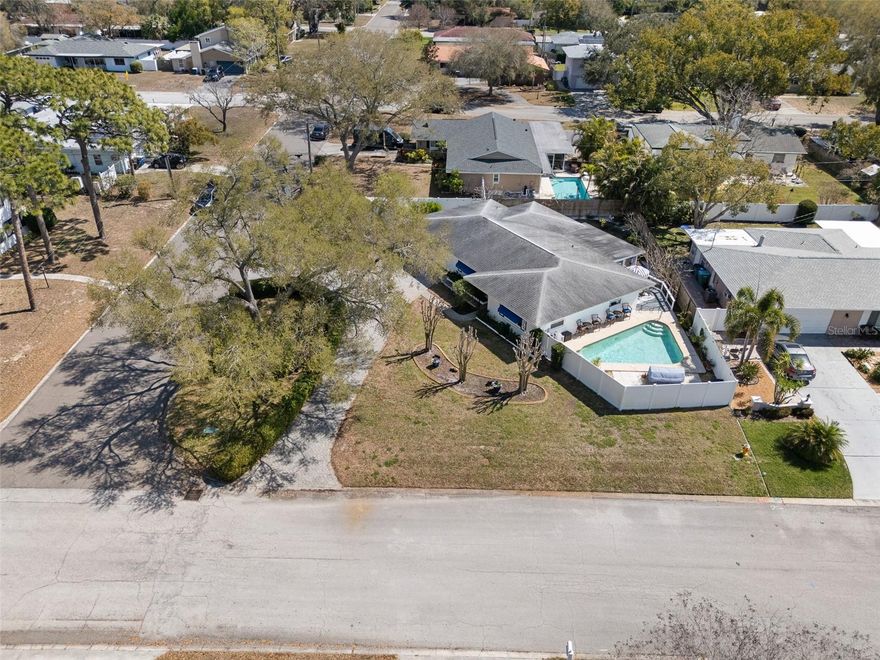 Beautifully updated 2-bedroom (Bonus Room Used as 3rd Primary Bedroom), 2-bathroom, 2-car garage pool home situated on a true corner lot in Clearwater and fully fenced for added privacy. The property features only rear neighbors, offering additional space and separation. Inside, you’ll find two generously sized bedrooms, plus a spacious bonus room with its own attached bathroom. While not designated as a bedroom (no closet), the bonus room is currently being used as the primary bedroom, providing flexible living options. Major improvements include hurricane-impact windows and doors installed in 2024, updated interior doors and baseboards throughout, HVAC replaced in 2023 (serviced annually), electrical panel updated in 2022, roof replaced in 2013, and new pool pump in 2025. Interior and exterior paint were completed in 2022 along with fresh knockdown drywall finish. The kitchen appliances convey, including refrigerator, stove, microwave, washer, and dryer. Electric water heater was flushed in 2026. Bathrooms include new toilets and updated hardware. The chlorine pool is maintained monthly, and the septic system was serviced in 2022. Two exterior cameras and video doorbell convey. Utilities include Duke Energy electric, City of Clearwater water, septic sewer, and Spectrum cable with fiber optic service available in the neighborhood. Trash and recycling pickup occur weekly.