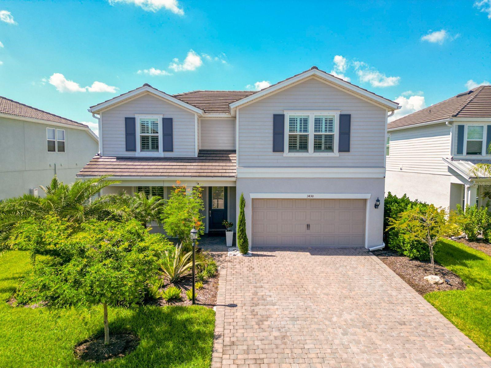 One or more photo(s) has been virtually staged. Exceptional opportunity to own this beautiful, one of a kind, CUSTOM POOL home located in the highly sought-after Mallory Park community in Lakewood Ranch. This stunning residence offers a truly remarkable living experience, featuring over 2800 sq ft, 4 bedrooms and 2.5 bathrooms, a dedicated office, and a versatile second floor bonus room. This Citrus Grove floor plan, built by Divosta, was meticulously crafted with high-end finishes that are sure to impress even the most discerning buyer. The interior of this home is designed for modern living, boasting luxury plank vinyl floors throughout the main level for a clean, contemporary aesthetic, custom plantation shutters, and shiplap accent wall in the great room. The gourmet kitchen is a chef's dream, equipped with top-of-the-line stainless-steel appliances, gas range with stainless-steel range hood, quartz countertops, a large island with breakfast bar seating, upgraded 42-inch upper wood cabinetry with a stylish tile backsplash and a spacious walk-in pantry with shelving. For added convenience and luxury, there's also a built-in wine rack and a KitchenAid beverage refrigerator. Open to the great room, the nearby dining area offers views of the backyard, making this floor plan ideal for everyday living and entertaining. Open the sliders and bring the outdoors in! The spacious first-floor master suite offers a private ensuite bath, complete with dual vanities, a walk-in shower, and a large walk-in closet. The three additional bedrooms are located upstairs along with a spacious bonus room, offering flexible space to suit your lifestyle needs. The outdoor living area is a true oasis, featuring a screened and covered lanai perfect for outdoor living and dining, a custom heated saltwater pool designed by former owners for Olympic training - enjoy morning laps - and luxury Astroturf green space surrounded by lush tropical foliage -- creating perfect outdoor space for relaxation and entertaining. Complete with a spacious laundry room and two-car garage with epoxy finished flooring. Mallory Park is a gated community in Lakewood Ranch that offers an active lifestyle. Residents enjoy maintenance free landscaping, a community pool, clubhouse, fitness center, dog park, playground, a dock for fishing overlooking the large pond, scenic walking trails, pickleball and basketball courts. Conveniently located near parks, sports fields, A-rated schools, SRQ Airport, and University Town Center for shopping and dining.