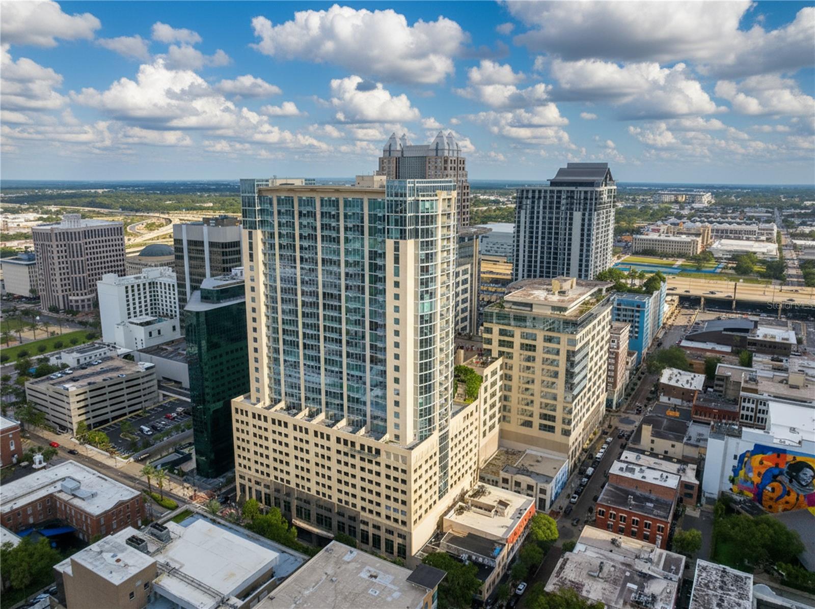 Welcome to Solaire at the Plaza, downtown Orlando’s premier destination for elevated, high-rise sophistication. This exquisite 1-bedroom, 1-bathroom residence embodies modern elegance, refined comfort, and effortless style, the ultimate sanctuary for those who crave the energy of the city and the serenity of luxury living. Perched high on the 27th floor, this bright and beautifully appointed condo offers breathtaking panoramic views from your private balcony, creating the perfect setting for morning coffee or evening sunsets. The open-concept layout flows seamlessly, enhanced by gleaming travertine floors, fresh designer paint, and brand-new, stainless steel, top-quality appliances. All major appliances, including an in-unit stackable washer and dryer, microwave (with oven and air-fryer capability), garbage disposal, dishwasher, refrigerator, and range, were replaced in the summer of 2025, ensuring modern efficiency and worry-free living. Industrial concrete ceilings and architectural accents add a unique, urban flair, while floor-to-ceiling windows bathe the space in natural light and capture the essence of downtown’s skyline. At Solaire, luxury meets convenience with 24-hour concierge service, biometric entry, state-of-the-art security, and a reserved parking space in a secure, nested garage. Residents also enjoy resort-style amenities, including a pool, fully equipped gym, and elegant clubhouse, plus internet included with HOA. Solaire is also on the same power grid as the hospitals just down Orange Avenue, and has not lost power in 14 years, providing unmatched reliability and peace of mind. Step outside and immerse yourself in the vibrant Downtown Arts District Orlando (DADO). Close to restaurants, bars, shops, coffee shops, Publix, beauty salons, Venture X workspace, Lake Eola Park, and the weekly farmers market every Thursday and Sunday, plus a special holiday market during Christmas. Cultural amenities like museums, the public library, and art studios are also nearby, offering an authentic downtown lifestyle at your doorstep. This is your opportunity to own a show stopping, move-in-ready residence with iconic skyline views and unforgettable sunsets, luxury living at its absolute finest.