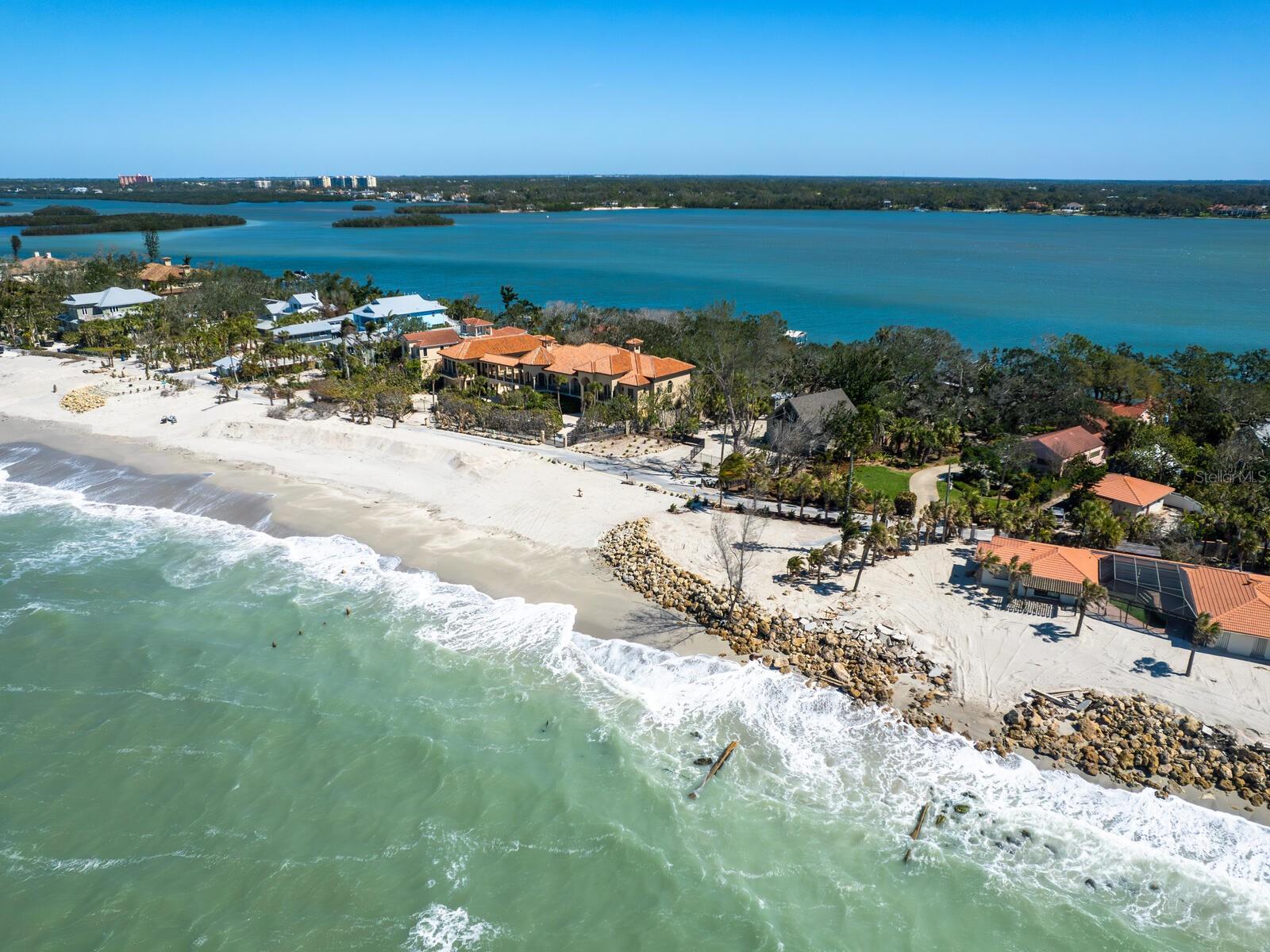 Seize the opportunity to own a piece of paradise on the exclusive North Casey Key. This sprawling one-plus-acre estate, with 107 feet of pristine gulf frontage, a walkable sandy beach, on a private road with security offering unparalleled privacy, is your personal slice of heaven. Surrounded by majestic live oaks, this property is a rare gem that embodies the timeless beauty of Old Florida living, offering a tranquil retreat with direct gulf-to-bay access. The three-bedroom, three-bath home exudes Mediterranean coastal charm and invites you to embrace the serenity of coastal life. With an expansive living room, formal dining room, country kitchen and an office, the home effortlessly combines comfort and style. Imagine cozying up with a cup of coffee in front of the fireplace in the primary bedroom as the first rays of dawn light up the sky over the Intracoastal Waterway, casting a soft glow on the water. As evening falls, step out and witness breathtaking sunsets over the gulf, painting the sky in hues of gold and pink, an enchanting end to every day. This completely fenced estate also offers a two-car attached garage and an additional three-car detached, air-conditioned garage, a dream for car enthusiasts who appreciate form and function. For boating lovers, a rare boathouse with a deck overlooking Little Sarasota Bay, two docks, one with a 7,500-pound lift, and a seawall, make it the ideal home for a waterfront lifestyle. Boat access to the gulf is a short five-minute ride through Midnight Pass. With direct access to the gulf, this property lets you indulge in the best of both worlds, an exclusive, private oasis and the beauty of the sparkling blue waters just near your door. On the exclusive north end of Casey Key, this estate offers seclusion and serenity, yet just five minutes from restaurants, Publix, CVS, 10 minutes to the City of Venice and 15 minutes to Sarasota. Commercial and private air travel is readily available. Don't miss your chance to live in one of Florida’s most desirable locations. With stunning sunsets, playful dolphins and soothing sound of waves as part of your everyday life, this is more than a home, it's a sanctuary. Experience the ultimate coastal lifestyle and make this paradise yours.