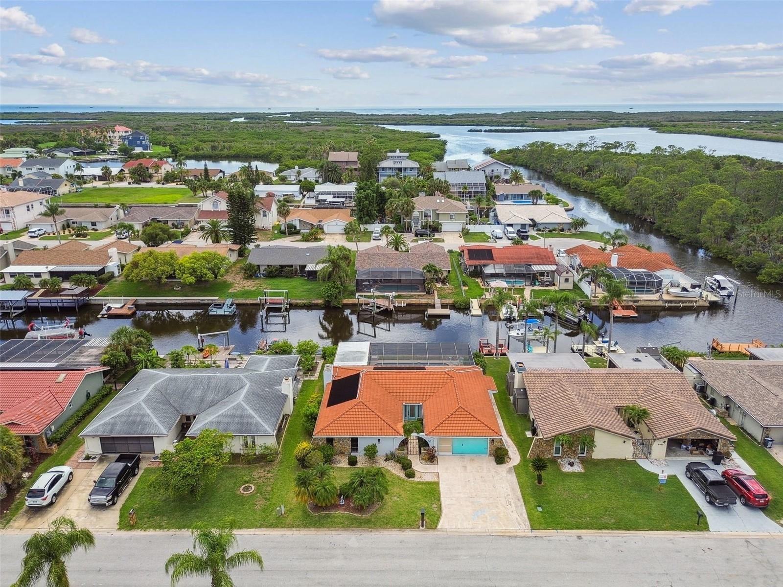 Welcome to this beautifully updated 3 bedroom, 2 bathroom waterfront pool home located at the end of a cul-de-sac in Port Richey. From the moment you arrive, you’ll notice the home’s impressive curb appeal with a tile roof, wide driveway, and private gated courtyard entrance. Inside, the open concept layout features new flooring, modern lighting, and a spacious design perfect for everyday living or entertaining. The split bedroom floor plan offers a large primary suite with double sliders to the pool, dual closets, and a fully renovated en-suite bathroom with a frameless glass shower and double vanity. The kitchen has been thoughtfully upgraded with quartz countertops, soft close cabinetry, a stylish bar area, and brand new high end appliances. Enjoy a cozy family room with an electric fireplace and stunning views of the water right from the kitchen sink. The interior laundry area is conveniently tucked behind a barn door, and both bathrooms have been completely remodeled with contemporary finishes. Step outside to the expansive screened lanai with a large pool and direct canal access perfect for boating, relaxing, or entertaining. This home truly offers the best of Florida waterfront living in a move in ready package. Roof 2007