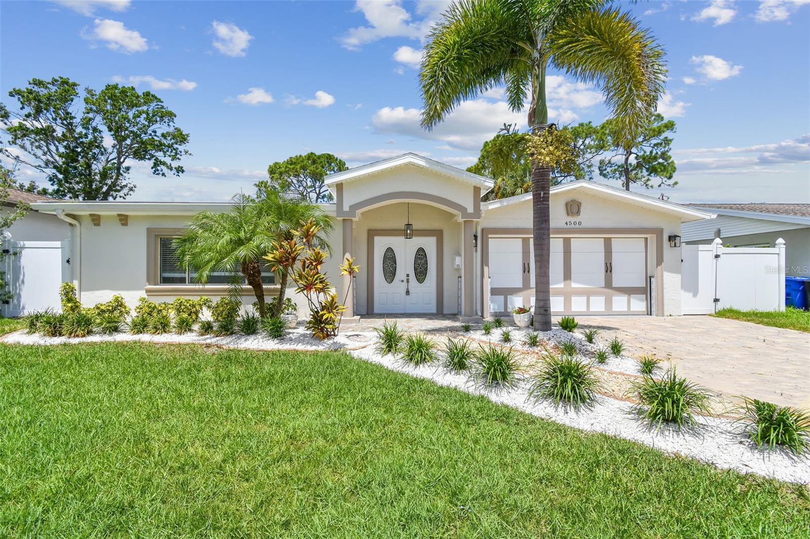 One or more photo(s) has been virtually staged. Welcome to your own slice of paradise in beautiful St. Petersburg! This beautifully updated POOL home offers the perfect blend of luxury and comfort. With 4 bedrooms and 3 bathrooms, this home awaits those who want to embrace the Florida lifestyle. As you step into the open-concept floorpan, you are welcomed with an inviting living space, porcelain tile, and refreshed interior paint. The sleek, modern kitchen is a true showstopper, featuring waterfall-edge countertops, brand-new appliances, a built-in wine fridge, and a stylish coffee bar for your morning routine or evening unwind. Just beyond the kitchen, a secondary living area offers the perfect space for casual family gatherings and entertaining with ease. The spacious primary suite features a walk-in closet and a fully updated bathroom. There are three additional bedrooms that are generously sized, offering versatility for family, guests, or a home office. Each room designed to provide comfort and style with new luxury vinyl flooring and abundant natural light. An indoor laundry room offers convenience and additional storage. The oversized 2-car garage boasts a durable epoxy finish with driveway space for up to 4 additional vehicles. In your own private backyard oasis, the pool is surrounded by tropical landscaping. The spacious patio area offers plenty of room for lounging, dining, and hosting - plus there's still room to personalize the space with a garden, fire pit, or outdoor kitchen. Recent updates ensure peace of mind, with A/C units replaced within the last five years. Tucked in the heart of Shore Acres, this home is just a golf cart ride from downtown, the St. Pete Pier, and top dining and shopping destinations. This home welcomes you with open arms, schedule your showing today!