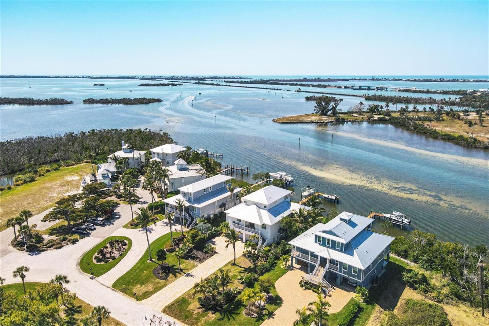 Savor the incredible Charlotte Harbor views and superb deep water boat access from this classic Key West styled, 2016 built home. Situated in the gated Angler's Club neighborhood, the home sits directly on the open bay with no bridges, looking south to Gasparilla Sound, Boca Grande and Charlotte Harbor, where you can enjoy the breathtaking views and bustling nautical activity from the moment you step through the front door. It's hard to pull yourself away from the multiple outdoor living areas that offer lounging, living and dining spaces. Just steps out the back door is the large dock and with the 10,000 lb and 3,000 lb boat lifts you can pick the type of boating or fishing you want for the day. The property has a brilliant layout that takes full advantage of the waterfront location where picturesque views pour into virtually every room in the home. The 3 bed, 3 bath home offers a beautiful chef's kitchen with quartz counters and a gas range, large double pocketing sliding glass doors in the main room brings the views and outdoors inside, a gas fireplace and built-in shelving, wrap around porch, 2 immense decks, screened porch, and a massive 4+ car air conditioned garage. Rigorous construction quality and premium materials, the home offers impact resistant windows and doors, some hurricane shutters for additional protection, Trex decking on all outdoor staircases and decking, metal roof, and Hardie Board siding. The Anglers Club community offers a 1,000 foot community dock, pool and clubhouse. The supreme boating and fishing location means you're instantly in some of the worlds best back water and Tarpon fishing, less than a mile to the Gulf of Mexico, and close to amazing destinations like Boca Grande Marina, Cabbage Key, Useppa Island, Captiva Island, Fisherman's Village, Bokeelia, and countless others. The community is next to the fantastic full-service Gasparilla Marina that provides fuel, bait, and mechanic services.