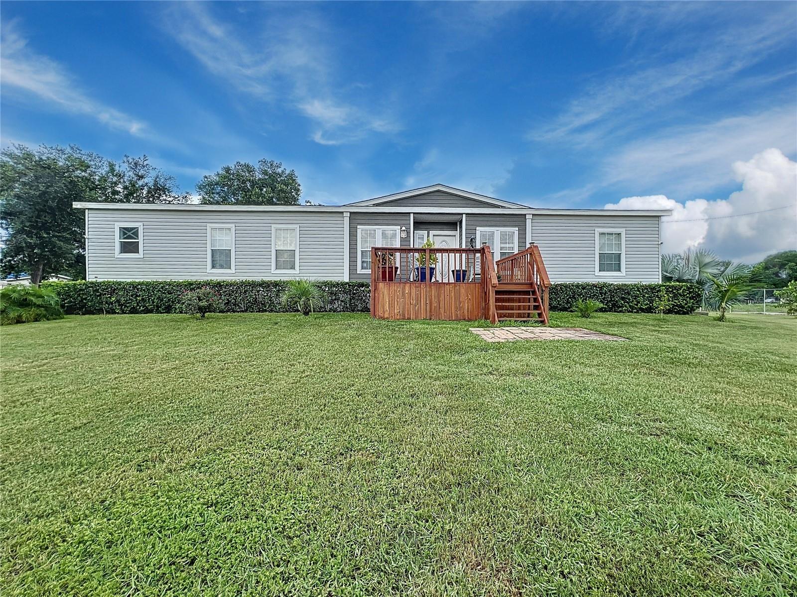 Spacious 2022-built double-wide manufactured home on approximately 1.5 acres in the fast-growing Haines City area—NO HOA or deed restrictions! This 3-bedroom, 2-bath home also features a versatile den/flex room and an open-concept floor plan designed for comfort and entertaining. The chef-style kitchen includes stainless steel appliances, double oven, cooktop, sleek range hood, and a large island that opens into expansive living and dining areas. Durable hard surface flooring throughout—no carpet. The split-bedroom layout offers a private primary suite with two walk-in closets and a luxurious bathroom featuring double vanities, a soaking tub, and a glass-enclosed shower. Enjoy rural living with room for RVs, boats, work trucks, or animals. A backyard workshop/shed provides additional storage or workspace. Conveniently located just minutes from shopping, dining, and major highways.