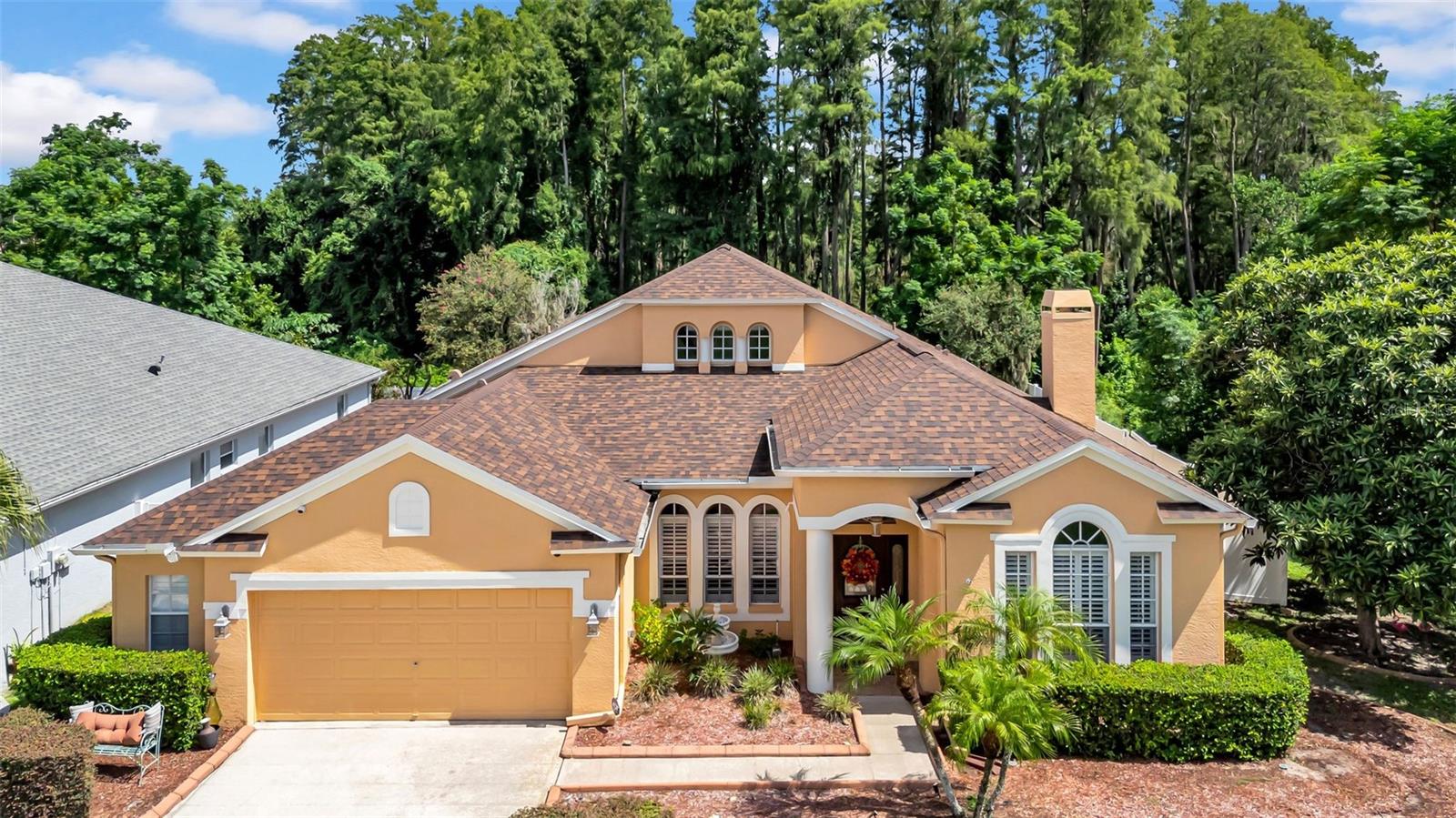 Welcome to your dream home in the heart of Land O' Lakes! This immaculate 4-bedroom, 3-bathroom pool home with a PRIVATE OFFICE is nestled in a CUL-DE-SAC on a premium CONSERVATION LOT offering serene nature views and only one side neighbor- perfect for those seeking peace and PRIVACY. From the moment you walk through the front door, you're greeted by soaring VAULTED CEILINGS, elegant archways, and rich architectural details that create a truly grand impression. You will absolutely love the cozy reading nook, library/study equipped with a woodburning fireplace-ideal for unwinding down. This home is truly move-in ready, featuring brand-new stainless-steel appliances, a new roof (2020), plantation shutters throughout the entire home, and fresh interior paint. The primary suite is a luxurious retreat, complete with brand new porcelain tile flooring, a spa-like bathroom with a garden tub, and a separate shower and a huge walk-in closet with built ins. One of the four spacious bedrooms is a private en-suite guest or in-law suite, thoughtfully tucked away for added privacy. The open concept lay out draws your eyes straight to the sparkling pool and lush conservation area beyond, blending indoor and outdoor living seamlessly. Along with the HEATED POOL AND SPA with waterfall out back, you will find a 16x15 covered area complete with a built-in grill, hood, and fridge perfect for outdoor entertaining and gatherings. With an OVERSIZED 2-CAR GARAGE and an array of exceptional features, this home is a true gem. Conveniently located just minutes from grocery stores, shopping plazas, the Land O' Lakes Recreation Complex, local gyms. You're only 10 minutes from Wesley Chapel Premium Outlets and have quick access to I-75, putting downtown Tampa and the airport within easy reach. Schedule your private showing today and fall in love with everything this home offers.