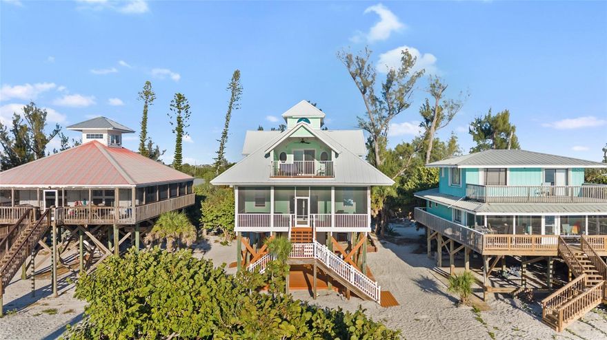 This beautiful gulf front home, located on Little Gasparilla Island, features a custom coastal design, with stunning views and a relaxing atmosphere. Little Gasparilla Island, a bridgeless barrier island off the Cape Haze peninsula, is accessible only by private boat or water taxi only. LGI has a peaceful and friendly atmosphere, with no shops, restaurants, or car traffic. Residents enjoy sandy trails, and lush tropical foliage. Every detail of this home has been carefully considered, creating a lovely living space that combines comfort and style. The metal roof, Hardie board siding and trim, Hardie soffit, and Hardie ceiling in the lanai were installed in 2023, along with impact windows and doors installed throughout the home, ensuring durability and safety. A full list of updated features is available upon request. On the first floor, you'll find a guest bathroom and bedroom, a laundry room, a kitchen, a living room, a dining room, and a large screened-in lanai. The kitchen is thoughtfully designed for those who love to cook and entertain, flowing seamlessly into the dining and living areas. The new windows and sliding glass door offer breathtaking views of the gulf and allow plenty of natural light to fill the space. During spring and fall, opening the windows and doors invites refreshing tropical breezes throughout the home. The spacious screened-in front lanai and the master bedroom balcony are perfect spots to sip your morning coffee or simply relax while watching dolphins and manatees swim by during the day. In the evening, you can enjoy spectacular sunsets over the gulf. On the second floor, the primary bedroom boasts two walk-in closets and an en-suite bathroom with a tub/shower combo, and a walk-in shower, and a double vanity. Each morning starts with a breathtaking view of the water from your bed. The second bedroom, also on the second floor, includes two rooms that make the most of the roof design, serving as storage space and an additional sleeping area. The home is equipped with two central vacuum units, one upstairs and one downstairs. Beneath the home is a storage area for keeping a golf cart, tools, fishing tackle, and beach toys. You can enjoy walking the beautiful 3 ½ miles of beach in search of perfect shells and shark’s teeth, or fishing for redfish, snook, snapper, and more in the surrounding waters. This well-kept beachfront home offers a unique opportunity to enjoy the coastal lifestyle. Once you visit and experience its charm and comfort, you'll never want to leave.