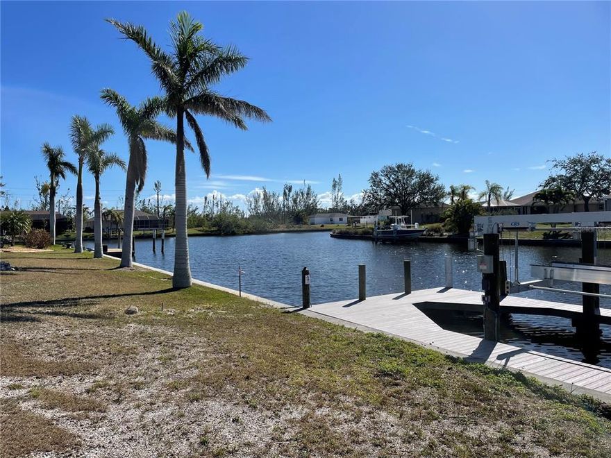 Spectacular oversized waterfront lot in the Premier boating community of South Gulf Cove. This lot is cleared, maintained by landscapers, with a 90' seawall on one of the wider 125' canals. It's a short ride to the Interceptor Lagoon and open water speed. The south facing rear view is of intersecting canals. The adjoining lots and the lots across the street are kept in a park like setting. PLUS there is a brand new composite double sided dock with a 10K lift boat lift!! No waiting on permits build your home and go boating. Speaking of building... need a builder? We have several local superior builders that we would be happy to put you in touch with. This is a unique property do not let it slip away.