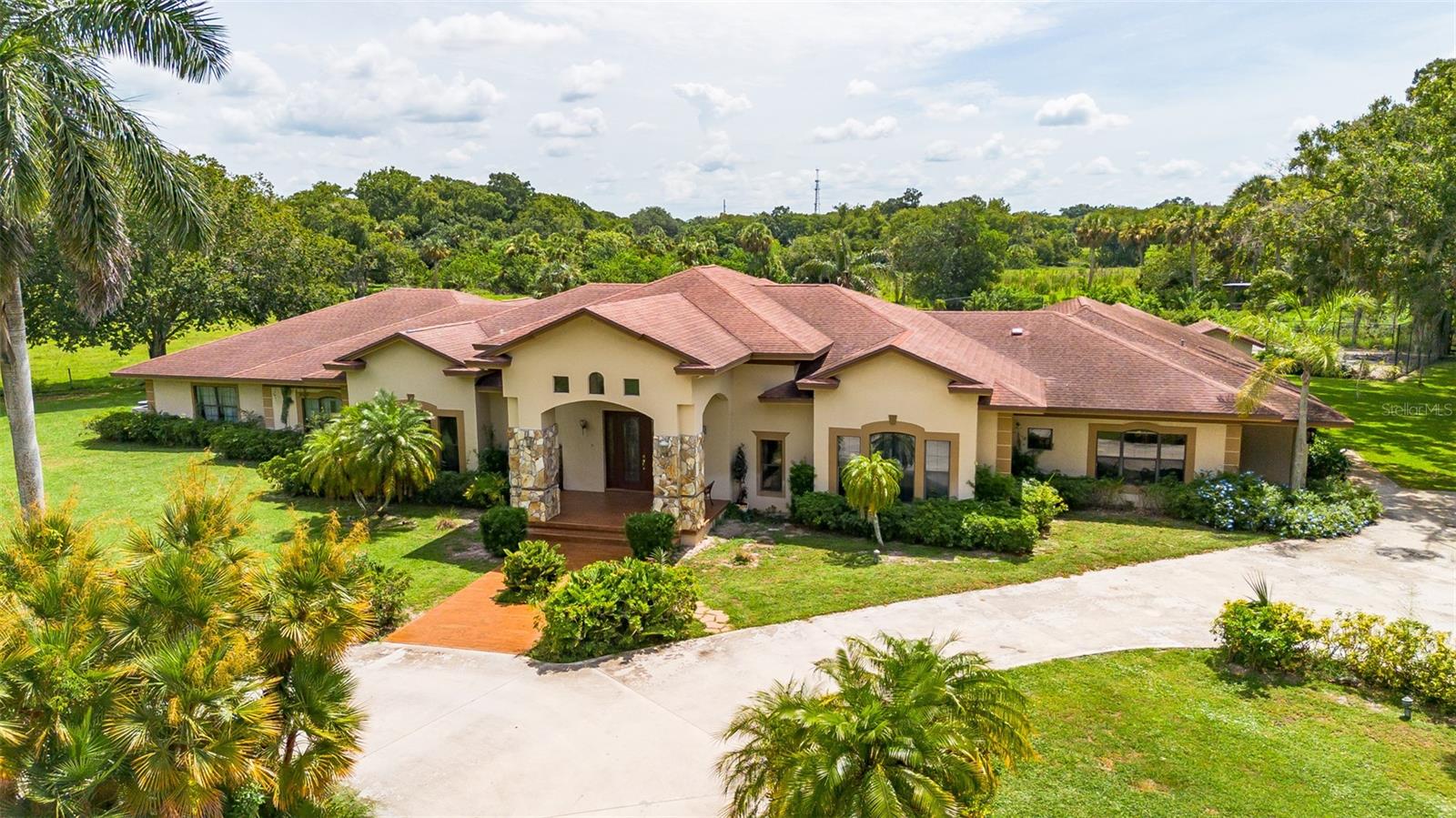 Welcome to your dream home with more than 7,400 square feet! Step through the grand foyer into a sunken formal living room with stunning views of the screened-in pool and patio - perfect for Florida living. This thoughtfully designed 4 bedroom, 3 bathroom residence offers space, luxury and flexibility for any lifestyle. Enjoy formal dining or casual meals in the eat-in kitchen, complete with both bar seating and a cozy breakfast area. A separate office provides the perfect work-from-home set up, while the oversized family/game room features a built-in bar that flows effortlessly into the pool area for indoor-outdoor entertaining.
Movie nights come alive in the dedicated theatre room, equipped with seven reclining chairs and a built-in projector system.
One bedroom has been converted into a spacious "lady's" closet, but you can easily be returned to a 5th bedroom if desired. The primary suite boasts his and her walk-in closets and a luxurious spa-style walk through shower.
The over-sized laundry room accommodates two washers and two dryer (one set stays), adding ease to your daily routine.
Outside, the property includes a separate garage with two large bays and an attached 1 bedroom, 1 bath mother-in-law suite - ideal for guests or multi-generational living. A double carport is tall and wide enough for an RV, boat or other recreational vehicles.
This unique home offers the best of space, style and comfort, all in a serene setting, just outside the city limits, with NO HOA.