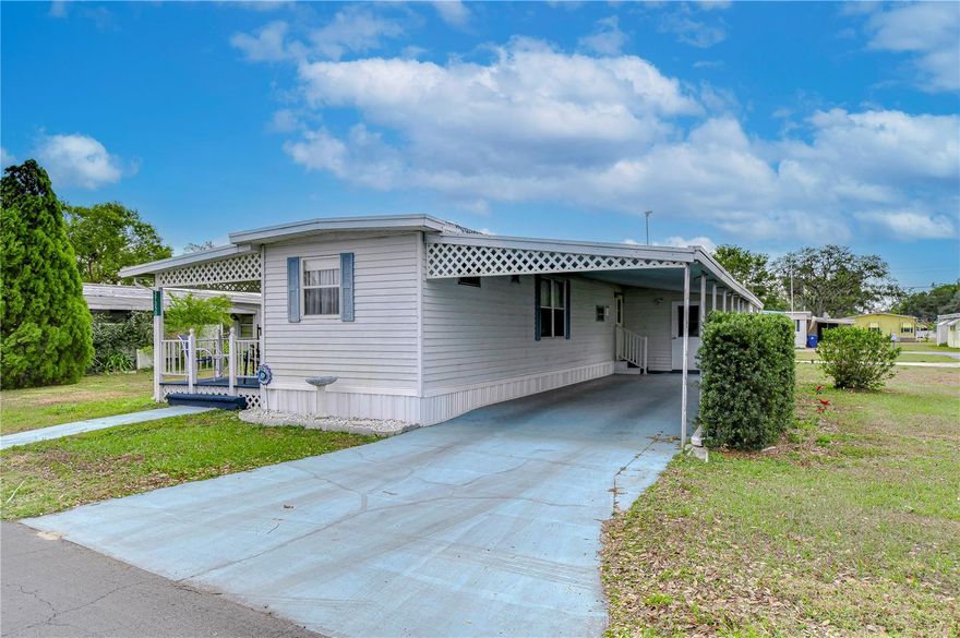 Beautiful corner lot near the clubhouse in this 55+ park. The home has an addition on the side of the living room and primary bedroom to the singlewide home. Entering from the front covered porch into the living room, the open floor plan allows the view of the kitchen and dining room The kitchen has a breakfast bar with a seating area. The guest bedroom is at the front of the home and has a half bath ensuite.  There are two built in closets and a built-in dresser. As you go down the hallway toward the rear of the home there is a side door entrance from the carport. Next is hall bath with a tub with shower. The primary bedroom across the hall has 2 built in closets and a rear door to the outside. The back bedroom is smaller and makes a great office or craft room. Don't let this one get away.  Call now for an appointment to see it.