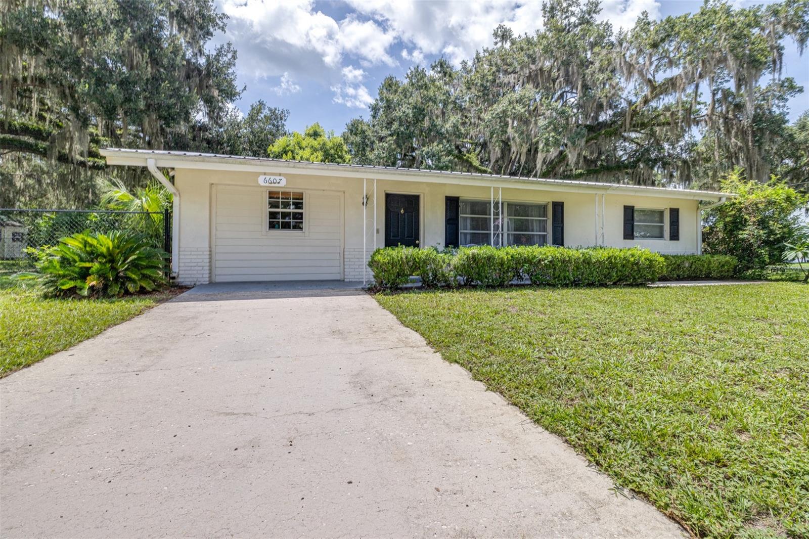 Welcome to your charming retreat in the heart of Floral City! Nestled on a spacious corner lot of over 1/3 of an acre, this well-maintained 2-bedroom, 1-bath home offers the perfect balance of comfort, privacy, and proximity to Florida’s natural beauty. Located just across the street from the stunning Tsala Apopka chain of lakes, and with a community boat ramp only 100 yards away, this property is ideal for outdoor enthusiasts and nature lovers alike. Situated on a peaceful loop with only one way in and one way out, the setting is tranquil and neighborly. Step inside to a bright and inviting living room that flows seamlessly into the dining area, with no carpet throughout—just clean, easy-care flooring perfect for everyday living. The two bedrooms and full bathroom are thoughtfully positioned on one side of the home, while the kitchen and laundry area are tucked on the opposite side, providing both function and privacy. The kitchen features solid wood cabinetry, abundant storage, and dual pantries. A cozy breakfast bar creates the ideal spot for casual dining or your morning coffee. Just off the dining room, the enclosed Florida room offers endless possibilities—think office, gym, hobby space, or simply a sunny spot to relax and enjoy the views of your backyard. Step outside to your fully fenced yard, complete with a brick paver patio for outdoor entertaining and a brand-new storage shed with electric hookup—perfect for tools, equipment, or a workshop. Recent updates include fresh interior paint, new flooring, a 2024 hot water heater, and a durable metal roof installed in 2021. Whether you're searching for a peaceful full-time residence or a weekend getaway with access to lakeside adventures, this delightful Floral City gem checks all the boxes. Don’t miss your chance—schedule your private showing today!