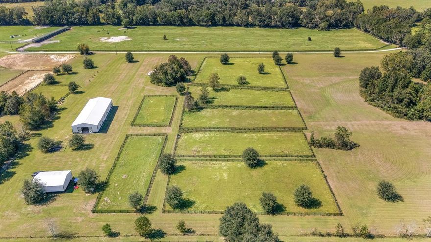 Turnkey 20-Acre Horse Farm in Prime NW Ocala Location.  Situated on a quiet, picturesque road surrounded by premier horse farms, this exceptional 20-acre equestrian property is a rare find in Ocala’s highly sought-after northwest corridor. Just 2 minutes from HITS and only 10 minutes to WEC, this turnkey farm is perfectly located for the serious equestrian.  The newly constructed center-aisle barn is thoughtfully designed and impeccably outfitted with 12 oversized stalls featuring European fronts, automatic waterers, and comfort stall mat system for ultimate equine comfort. The barn also includes two large grooming stalls, a climate-controlled tack room with custom cabinetry, and a spacious feed room complete with built in storage. A 1/2 bath with laundry adds convenience, while two outdoor wash racks, a water filtration system, and an large three-bay equipment garage/workshop/storage round out the amenities.  Additional equine facilities include eight fenced paddocks, each with water and separated by safe grass 'hacking' lanes. Enjoy an irrigated dressage arena, a large grass jump field, and plenty of room to school on the property. There’s even an RV hookup with septic for added flexibility.  A truly move-in-ready facility that blends high functionality with thoughtful design—don’t miss this rare opportunity in one of Ocala’s premier equestrian areas.  The property is being sold with tractor, zero-turn mowever, Jumps, etc.....  Property is ready for it's new owners for the 2025/2026 Horse Show Season.